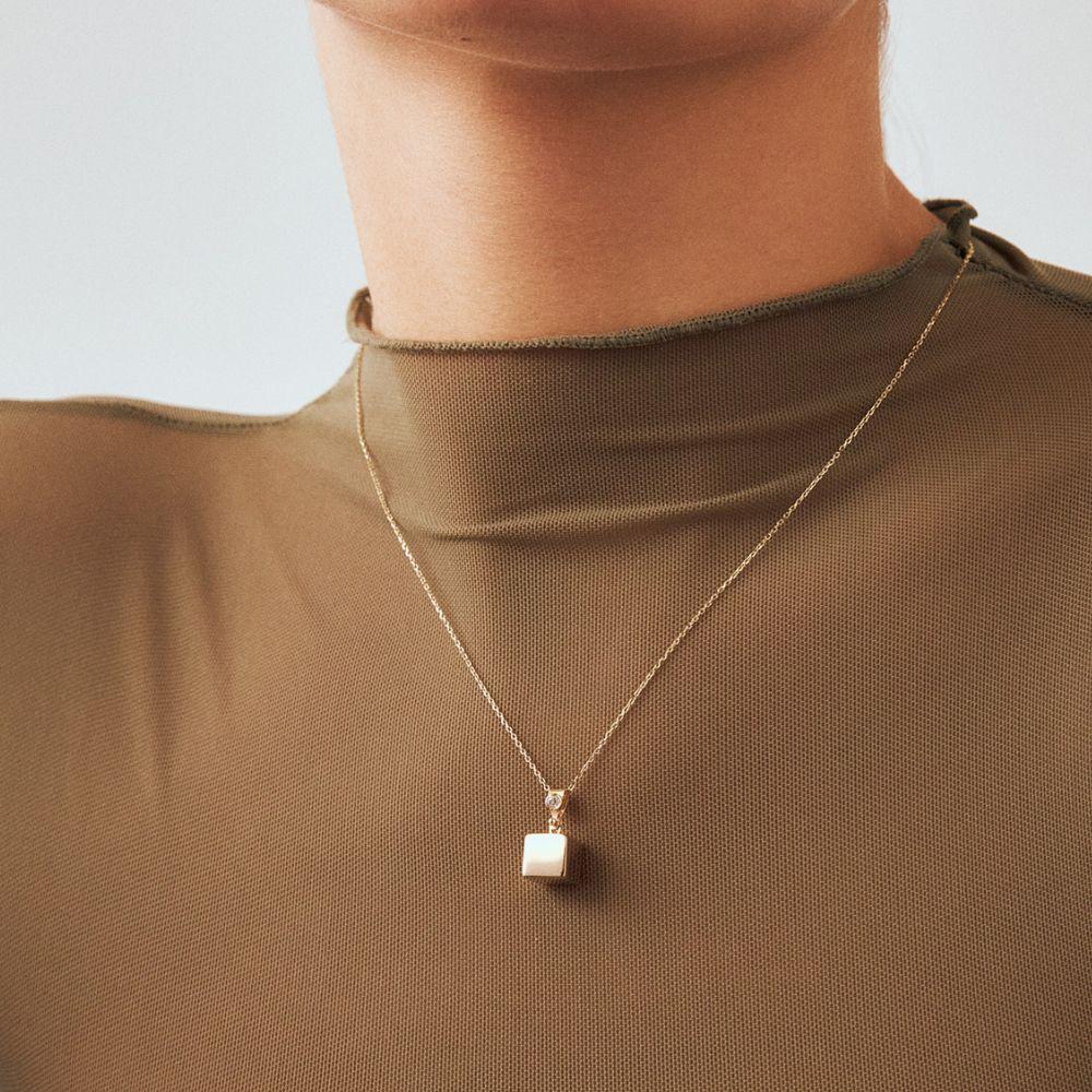 Ti presentiamo la collana con cubo di zircone in oro massiccio 14K, un riflesso della passione di Orena Jewelry per la fusione di stile contemporaneo e meticolosa maestria artigianale. Ogni singola collana è forgiata a mano con precisione e offre