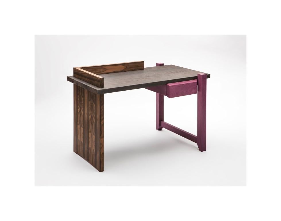 This small wood desk with simple shapes acquires sophistication through the different types of natural wood. A stylistic choice that brings out the craftsman's technical skill, a careful combination of colors chosen and selected by the designer just