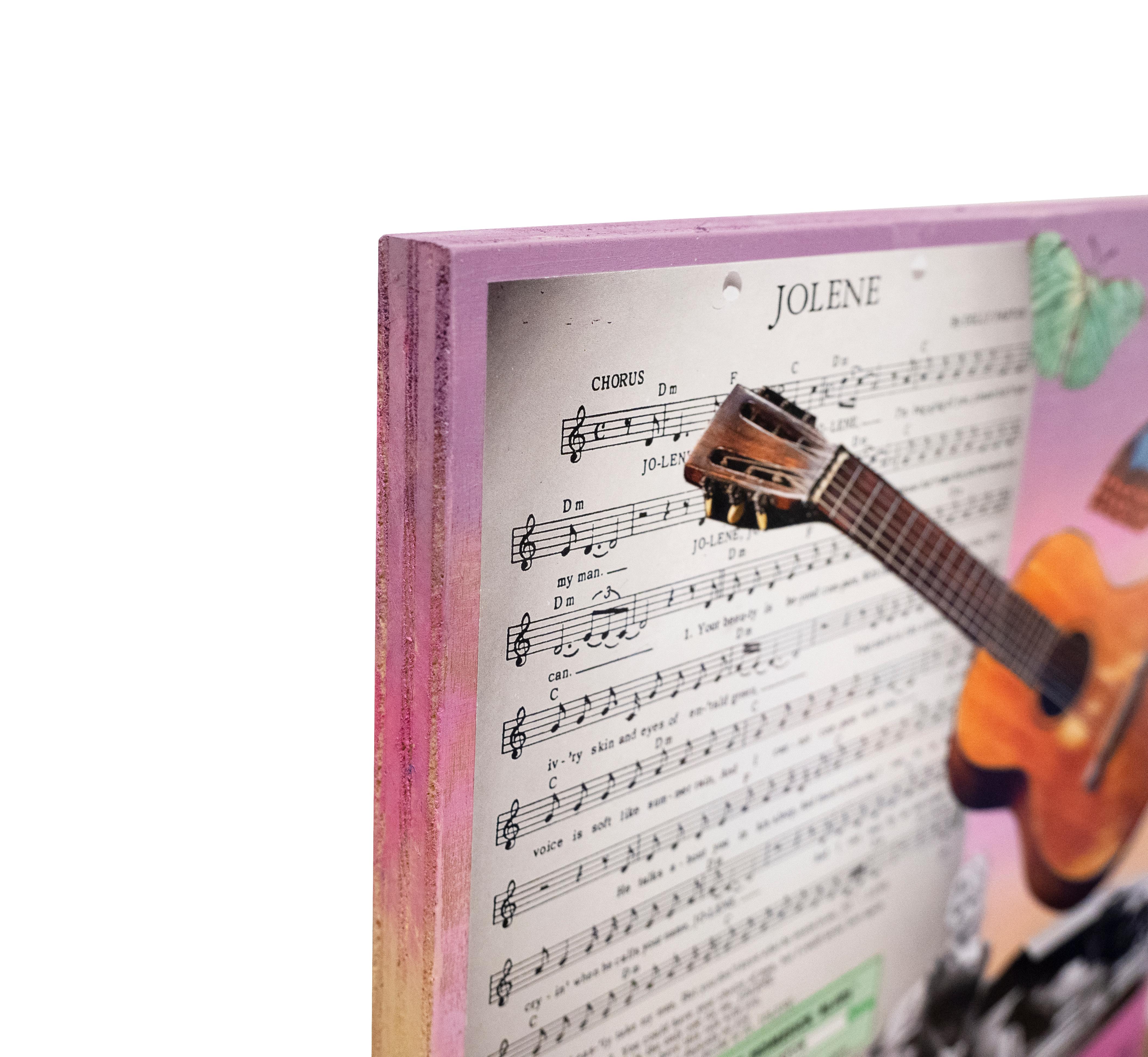 There's Something About Dolly... by Zoa Ace is a beautiful mixed media collage on painted wood of images of Dolly Parton, butterflies, a guitar and sheet music for her hit song 