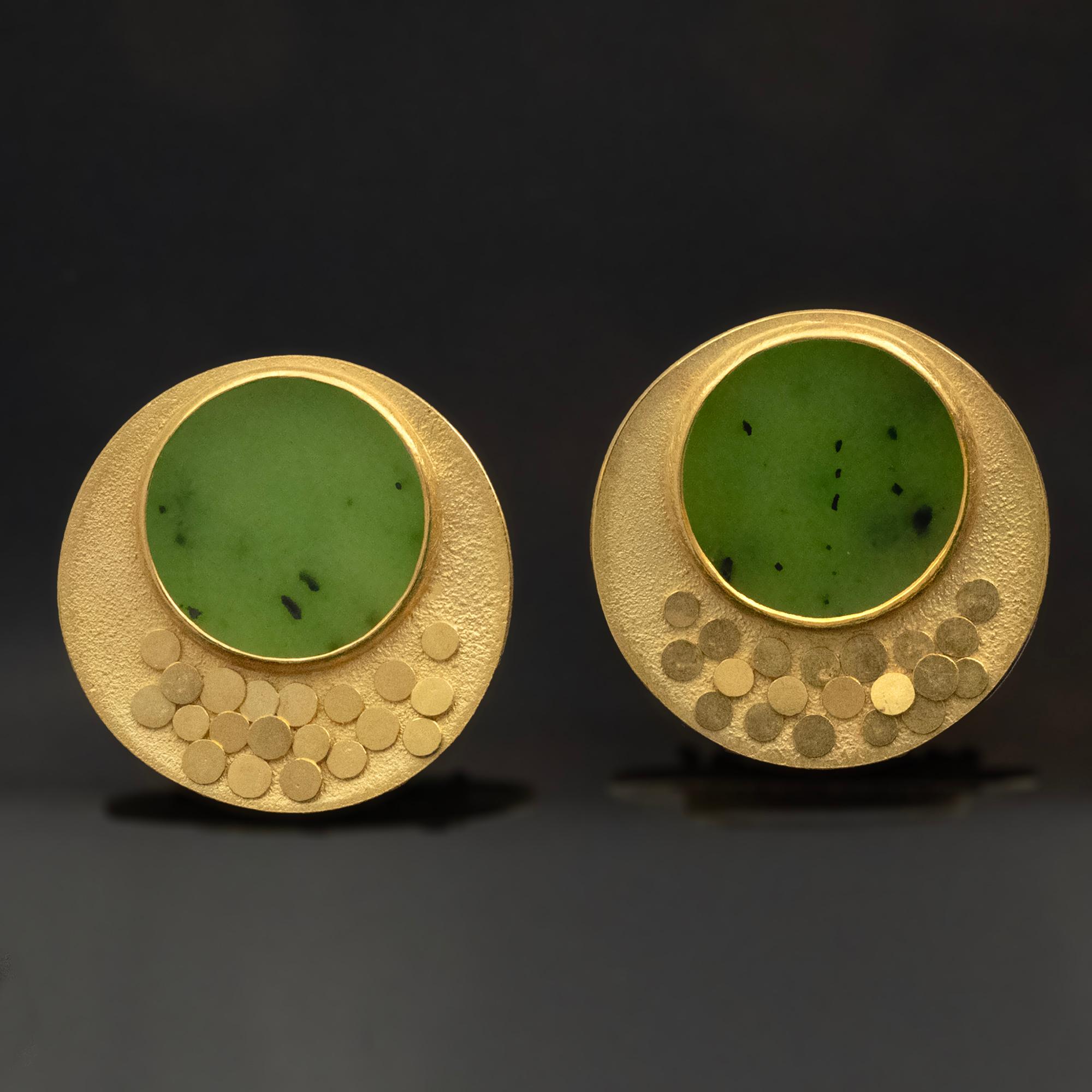  Moderne Ohrringe mit ethnischen Einflüssen machen es zu einem zeitlosen Stück, das man gerne trägt   mit Vergnügen bei vielen Gelegenheiten. Eine runde grüne Jade, eingefasst in strukturiertes Gold mit zwanzig schuppenartigen, beweglichen Scheiben.