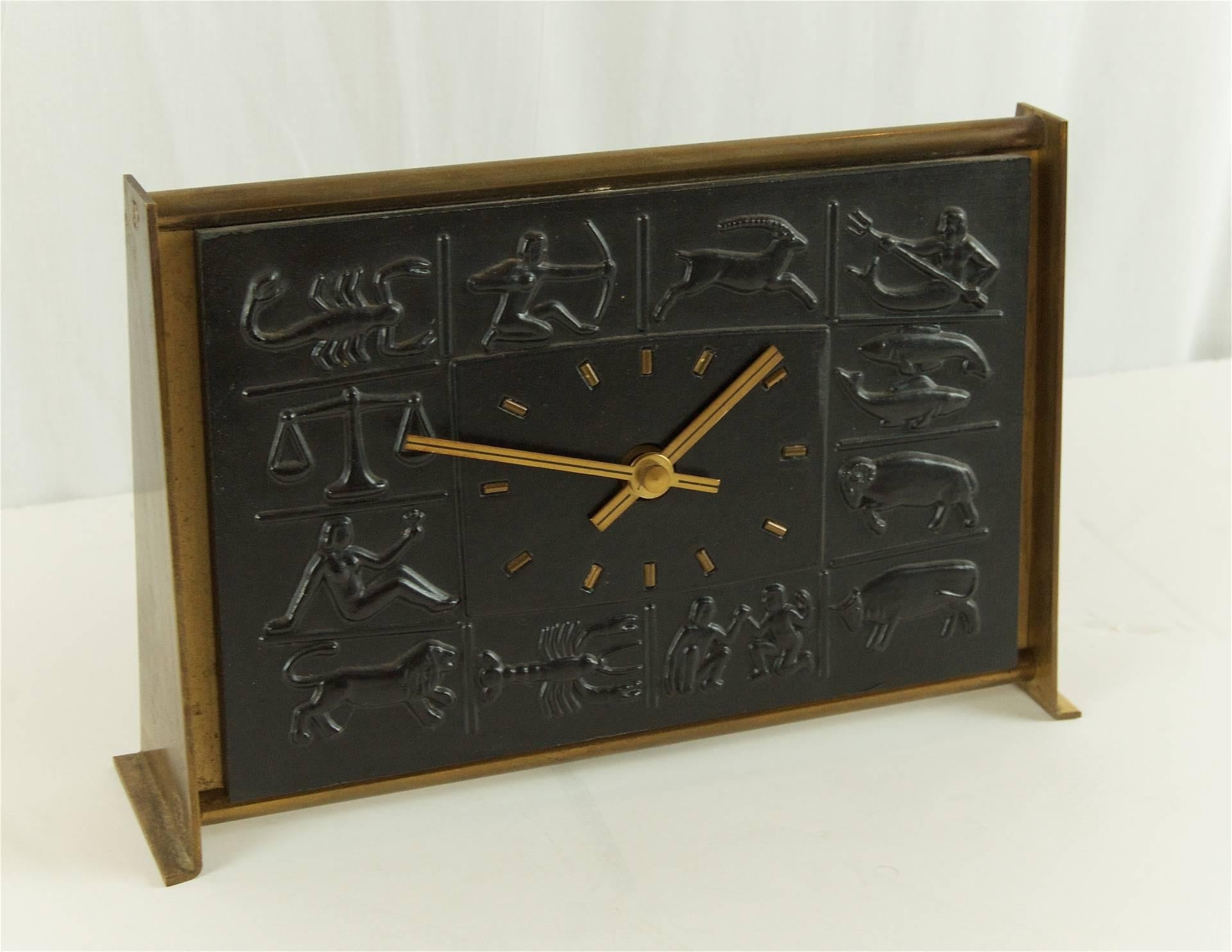 Unusual desk clock in brass and black bas-relief ceramic by Schatz.

Functioning, lacking battery compartment cover.