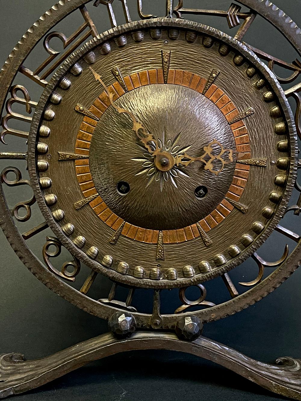 Cette grande horloge Art déco est composée de fer forgé et de cuivre, tous martelés et formés à la main. Le cadran central de l'horloge est entouré d'un travail ajouré représentant les symboles de chacun des signes du Zodiac. L'artisanat est