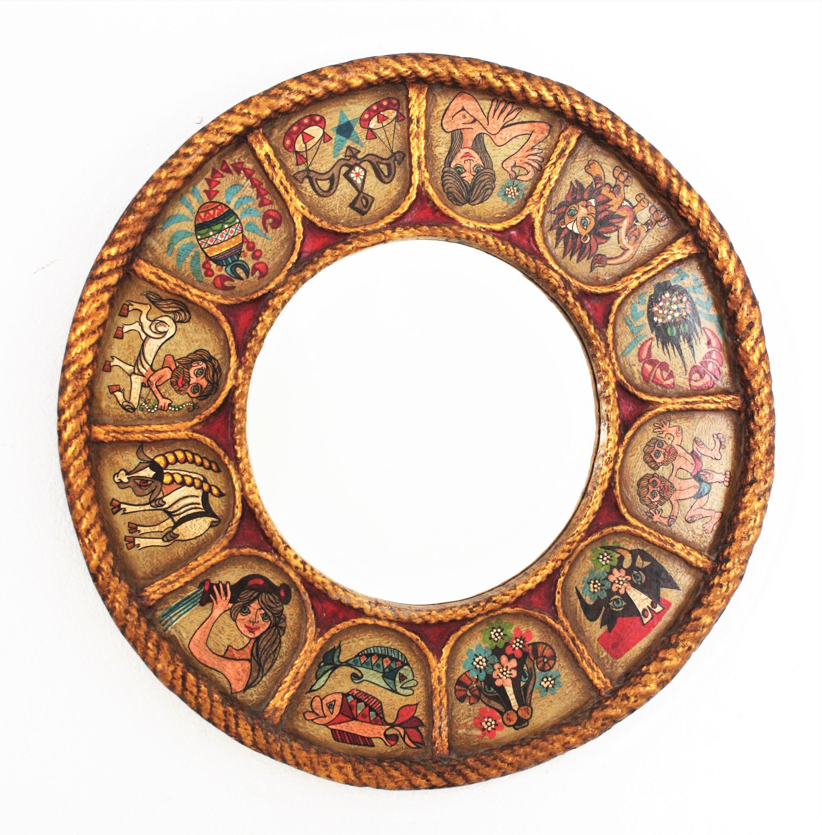 Zodiac round sunburst mirror in gilt polychrome wood, Spain, 1950s-1960s.
Handcrafted Horoscope mirror with giltwood round frame and hand painted polychromed 12 signs of zodiac arround the frame. 
Sunburst design surrounding the glass and Naif