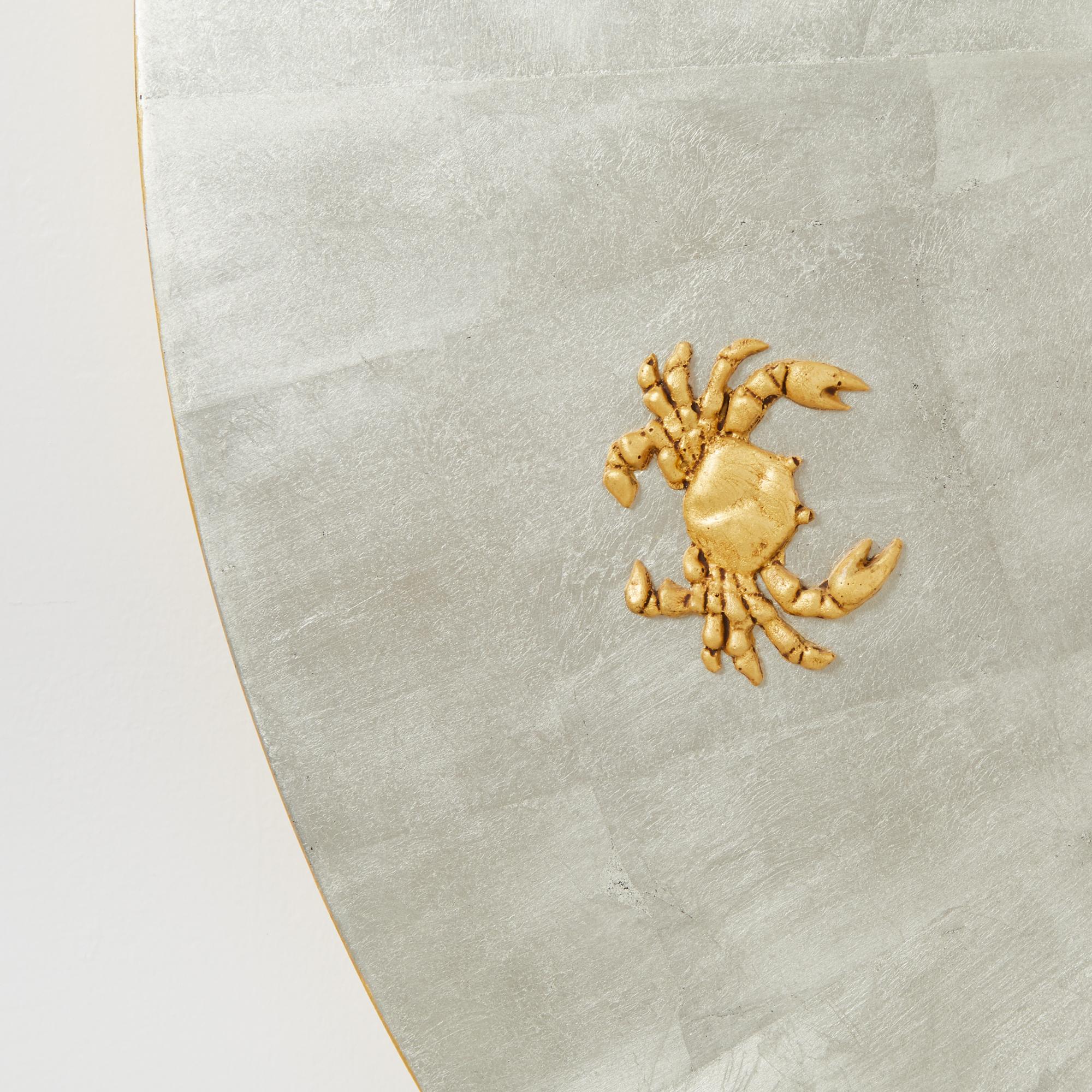 A disk shaped wooden frame with white gold leaf finish and 16” acrylic convex mirror. Low relief signs of the zodiac with yellow gold leaf finish encircle the mirror around frame. Also available in yellow gold or painted finish. By David Duncan