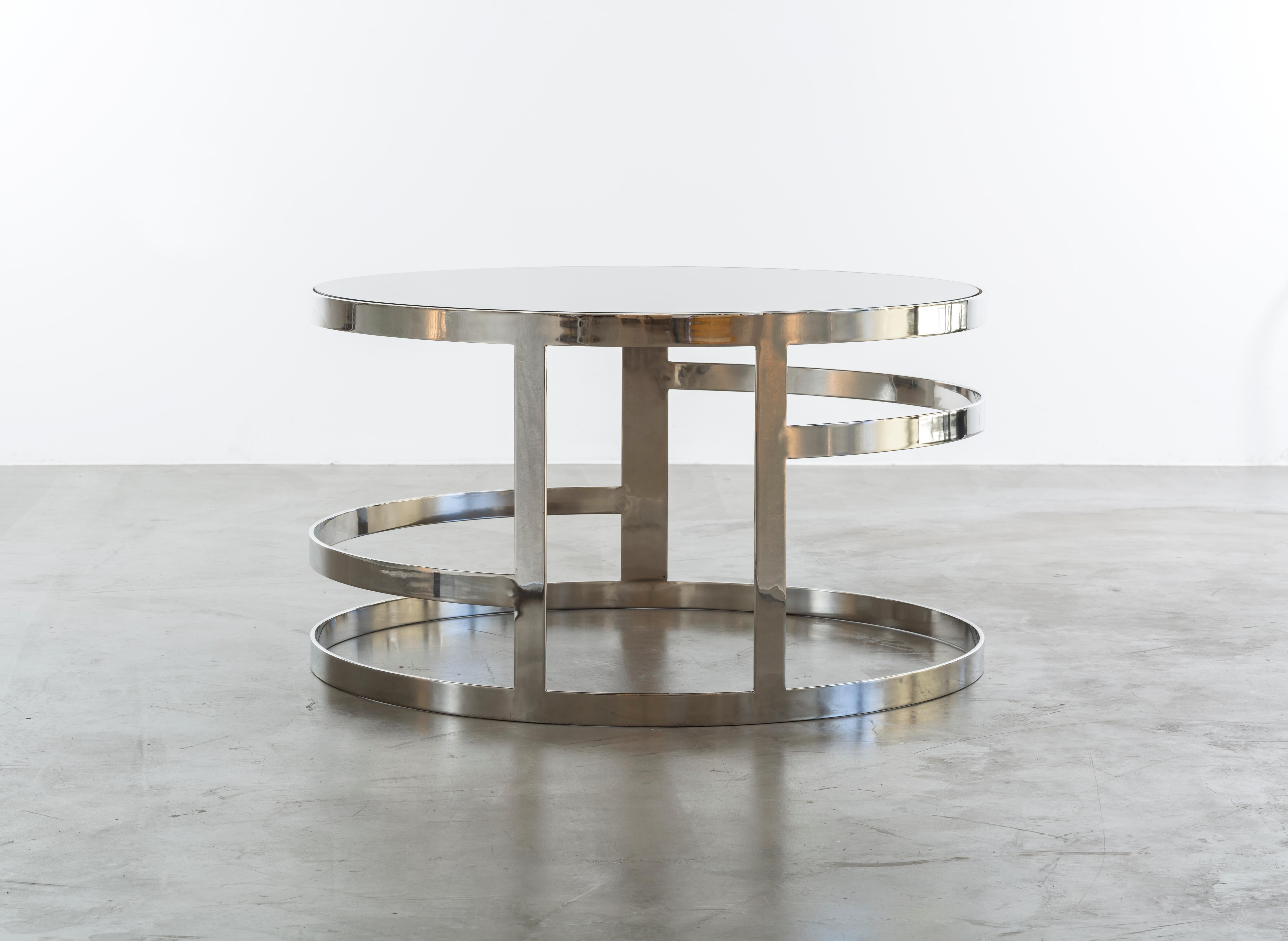 The Zoe coffee table is a modern coffee table in polished nickel with a smoked mirror top. Inspired by jewelry this coffee table is a real fashion statement for the home. Fully custom and made to order in California.