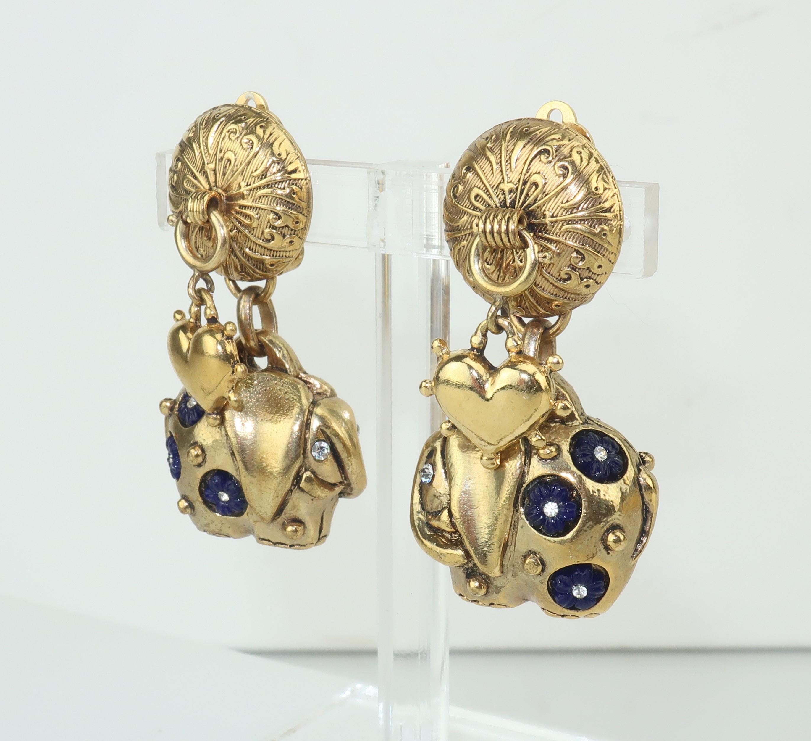 Charming!  Gold tone clip on earrings by Zoe Coste featuring hearts and elephants festooned with midnight blue glass and crystal rhinestones.  The dangling pieces are reminiscent of a charm bracelet with the hearts actually attached by a spring ring