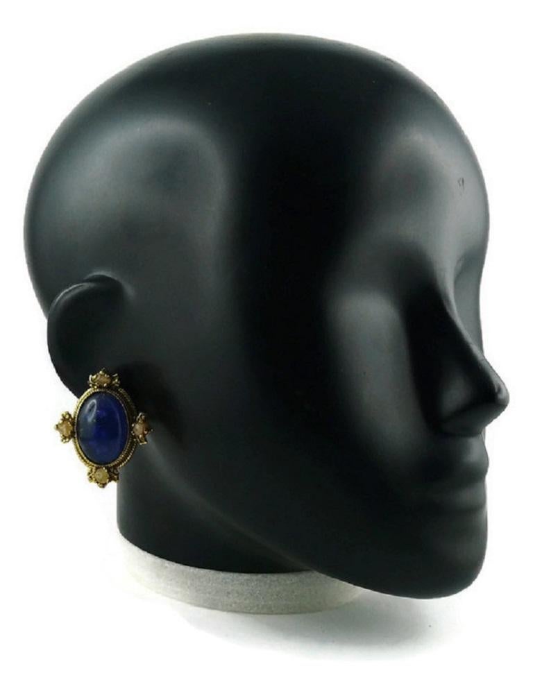 ZOE COSTE REMINISCENCE vintage gold toned oval frame clip-on earrings featuring a large lapis lazuli resin cabochon center surrounded by glass beads.

Embossed ZC REMINISCENCE Made in France.

Indicative measurements : height approx. 4 cm (1.57