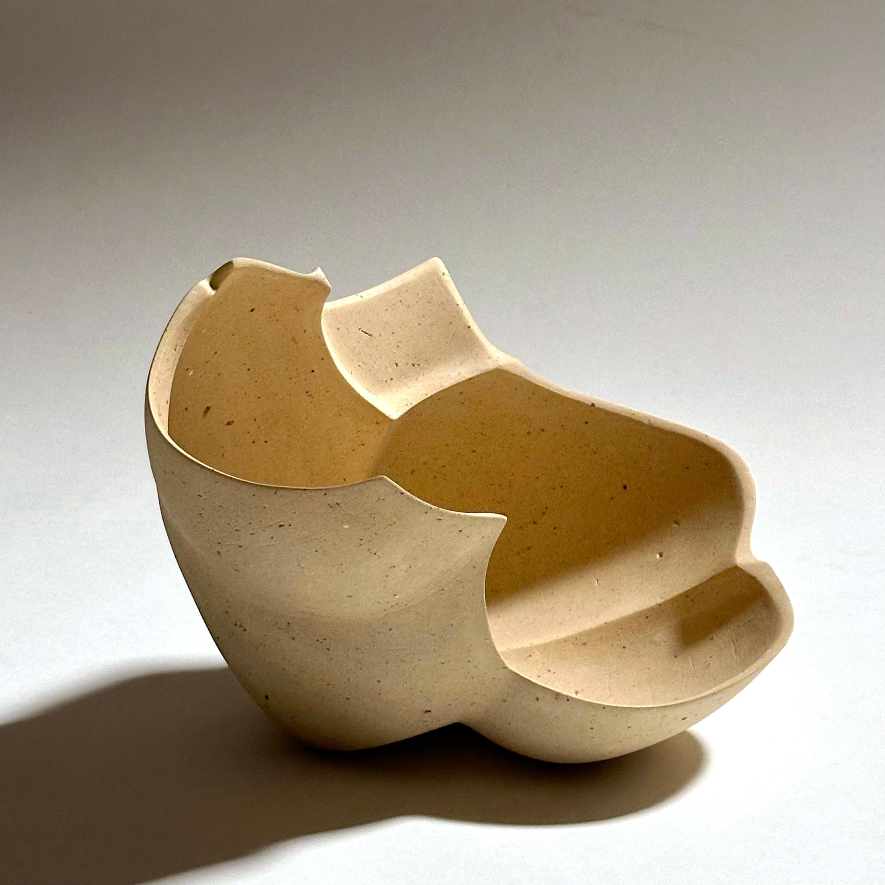 Scultura in ceramica a forma libera realizzata con una miscela di argille porcellanate e gres raccolte a mano dall'artista in Minnesota. La sua superficie è lucidata a mano con carta vetrata diamantata per ottenere una finitura opaca. Firmato con il