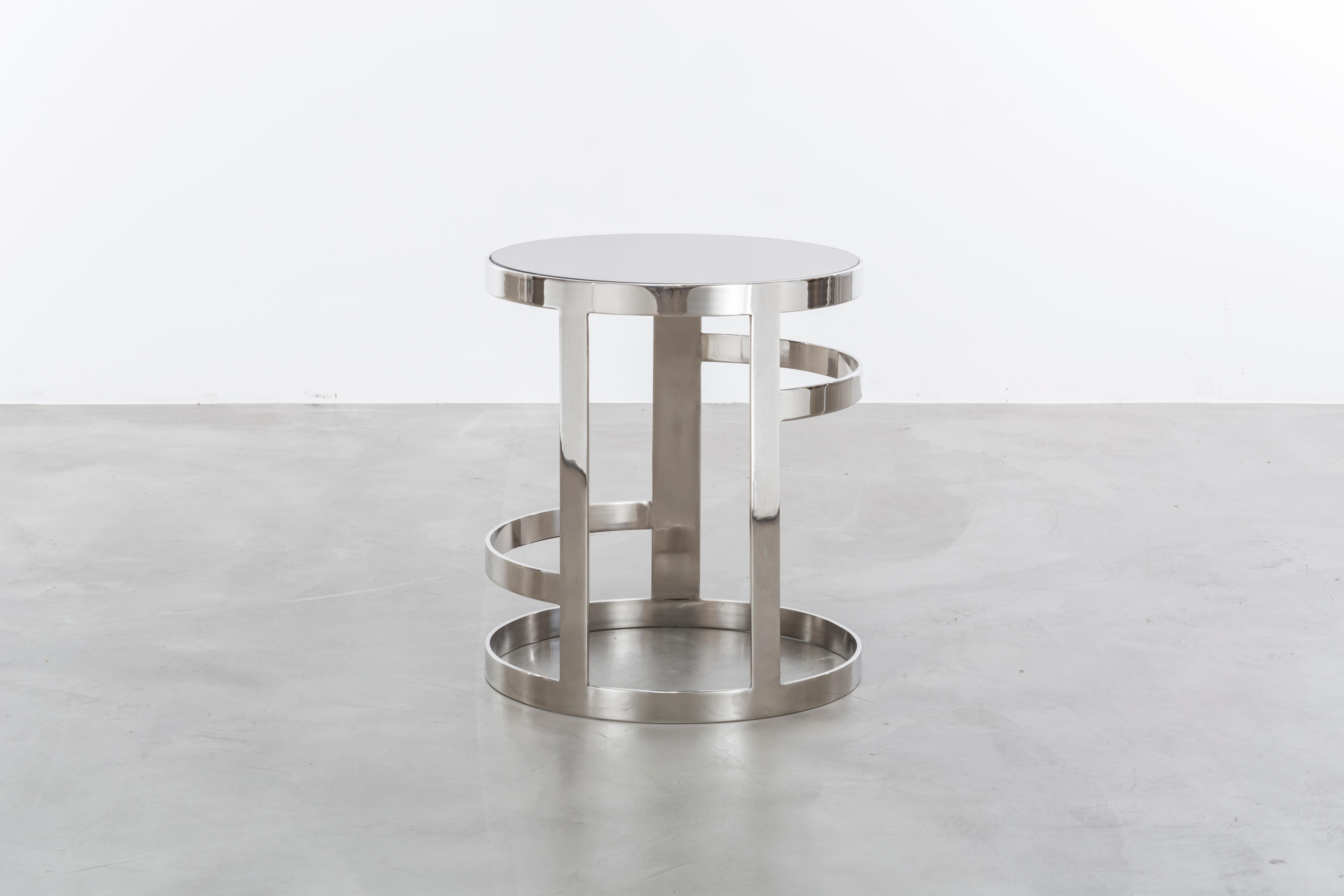 The Zoe side table is a modern side table in polished nickel with a smoked mirror top. Inspired by jewelry this side table is a real fashion statement for the home. Fully custom and made to order in California.