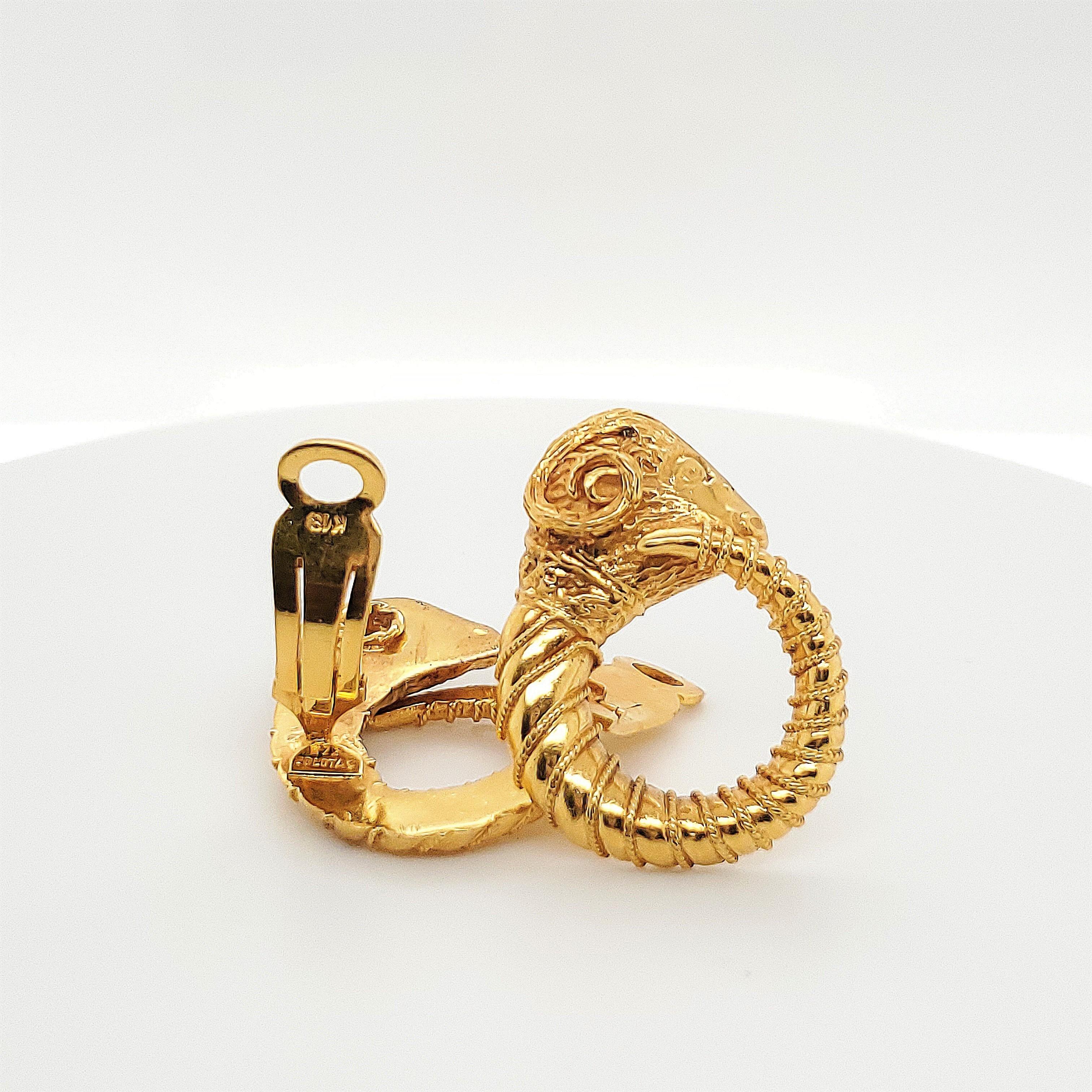 Authentic Zolotas earrings crafted in 18 karat yellow gold.  The Zolotas signature style is evident in the strong design of these exquisite ram earrings.  Featuring a ram's head and tapering to a horn that wraps around to form a hoop shape.  The