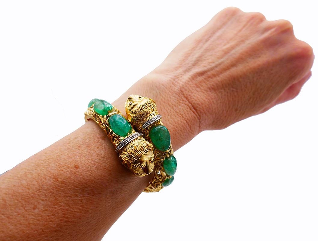 Recognizable Chimera Heads bangle by Zolotas. 
Made of 18 karat yellow gold, cabochon emeralds and accented with single cut diamonds. The diamonds are set in white gold.
Measurement:  1 ¼” x 6 ½” (3.2 x 16.5 cm). Fits up to 6 ¼-inch (16-cm) wrist.