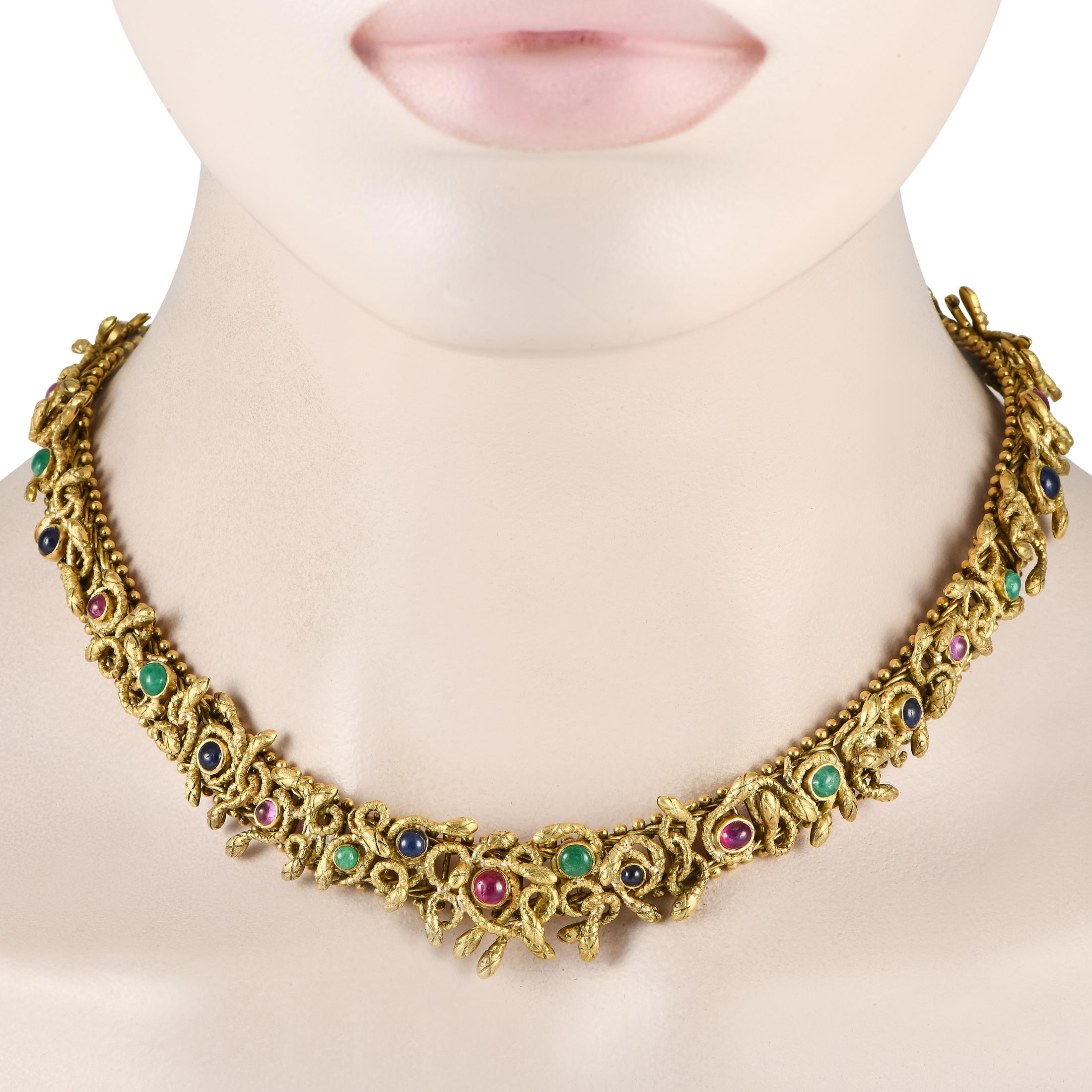 Ce collier en serpent de Zolotas a quelque chose d'incroyablement captivant. Réalisé en or jaune 18 carats, il présente un ensemble de figures serpentines entrelacées sur l'ensemble du motif. Les pierres précieuses émeraude, rubis et saphir ajoutent