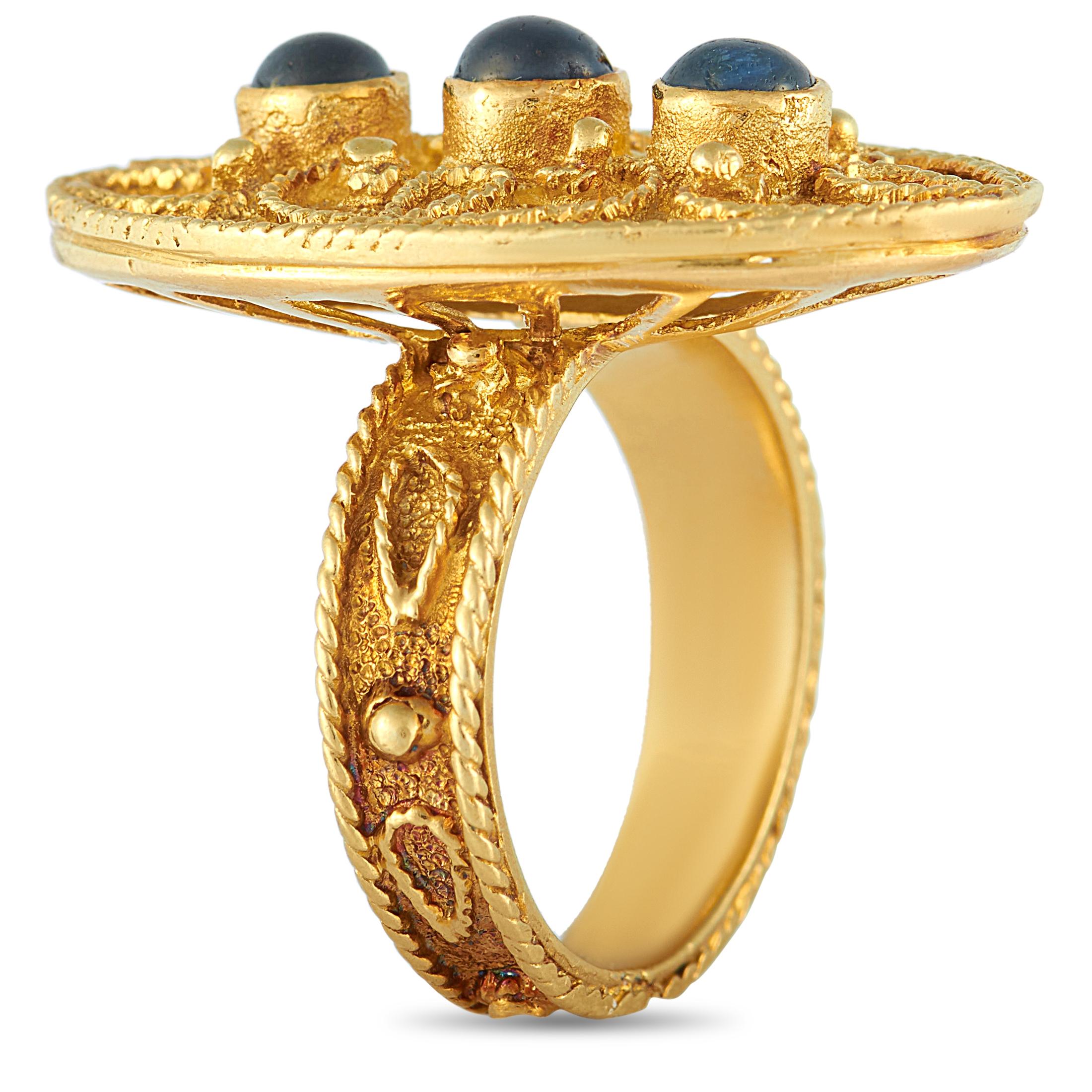 This Zolotas ring is made of 18K yellow gold and embellished wit
h sapphires. The ring weighs 12 grams and boasts band thickness of 4 mm and top height of 8 mm, while top dimensions measure 18 by 30 mm.

Offered in estate condition, this jewelry