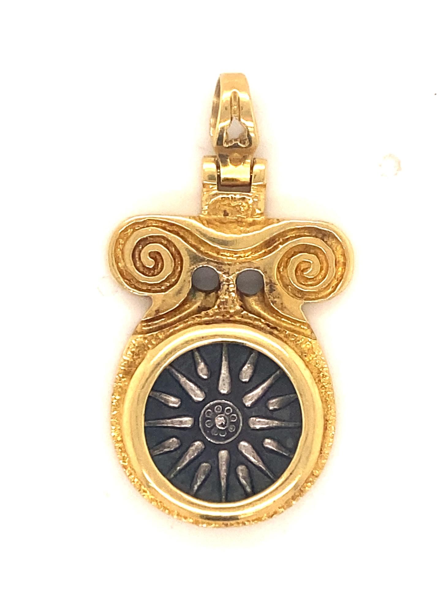 Dies ist ein schöner Anhänger des bedeutenden griechischen Designers Zolotas.  Der Anhänger ist aus 18 Karat Gold und mit dem Zolotas-Symbol mit den Nummern B56 und 750 versehen.  Bei der Münze handelt es sich um eine antike Silbermünze, auf der die