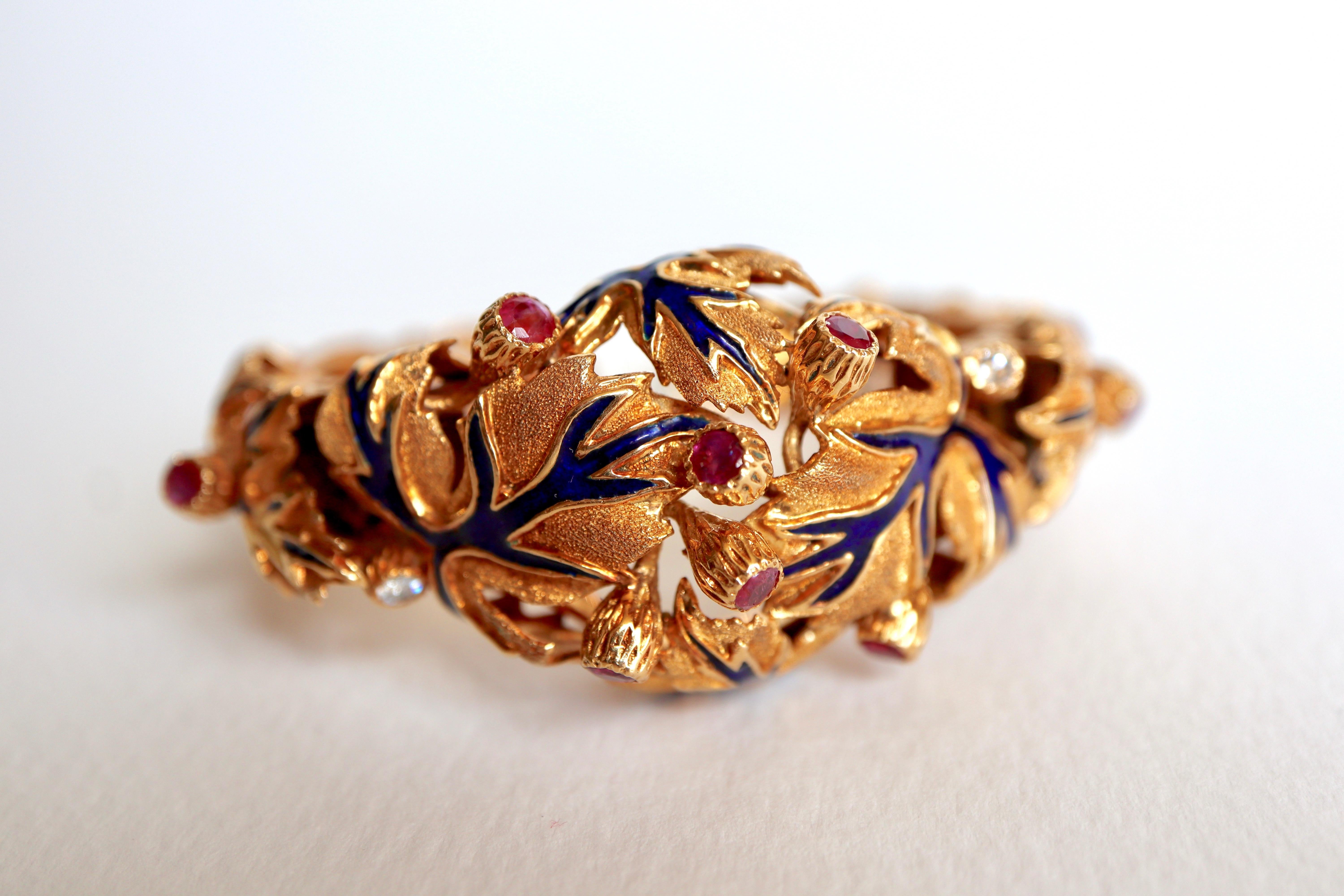 Zolotas Bracelet en or jaune 18 kt ciselé souligné d'un motif de feuilles en émail bleu ponctué de boutons de fleurs sertis de rubis et de diamants. Le bracelet est articulé en deux endroits grâce à un mécanisme à ressort qui permet de le porter au