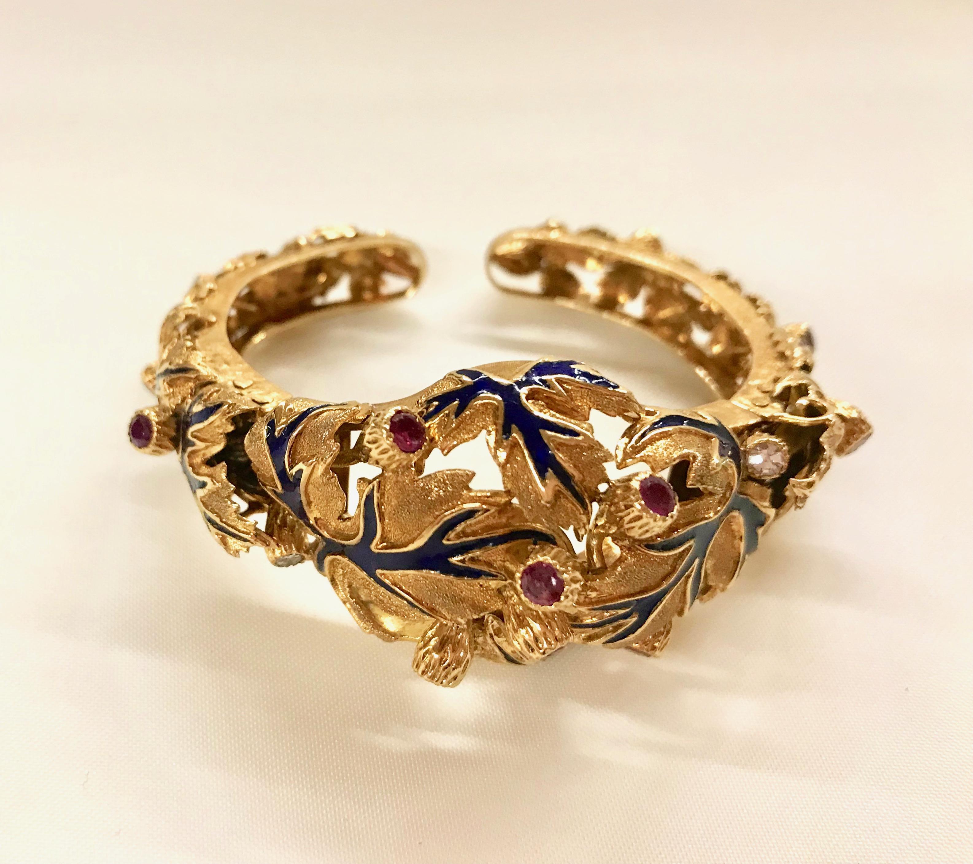 ZOLOTAS Bracelet in 18 kt yellow Gold engraved Foliage Pattern highlighted with blue Enamel punctuated with Rubies and Diamonds. 
The bracelet is articulated in two places with a Spring Mechanism allowing to pass it on the Wrist. 
Size: 50 mm x 35