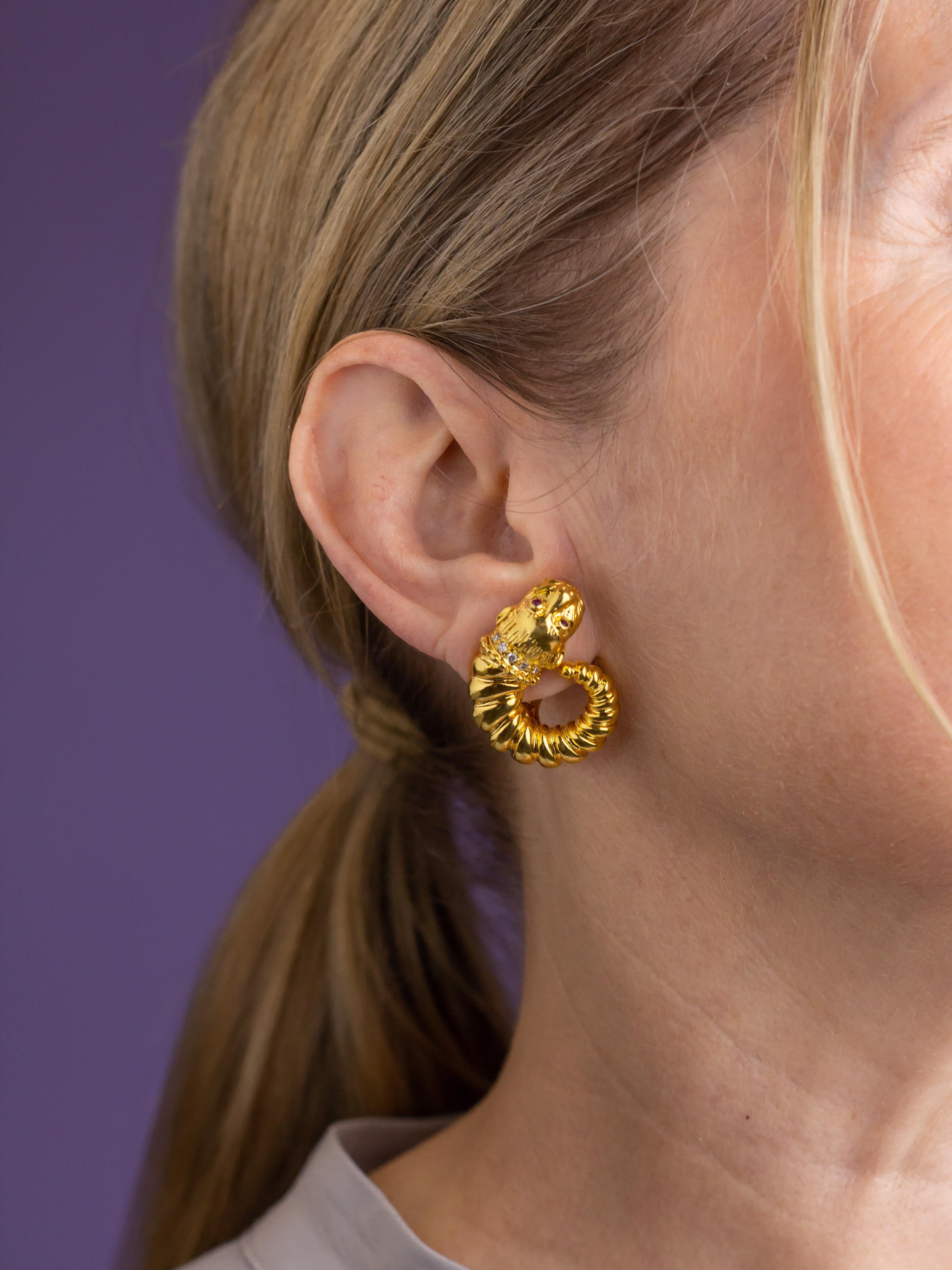 This pair of Greek made ear clips are by the famed jeweller Zolotas. Crafted from 18 karat yellow gold the clips are in the form of a 'chimera' which is a mythological, Greek, fire breathing creature, akin to a lion. Each clip features two rubies as