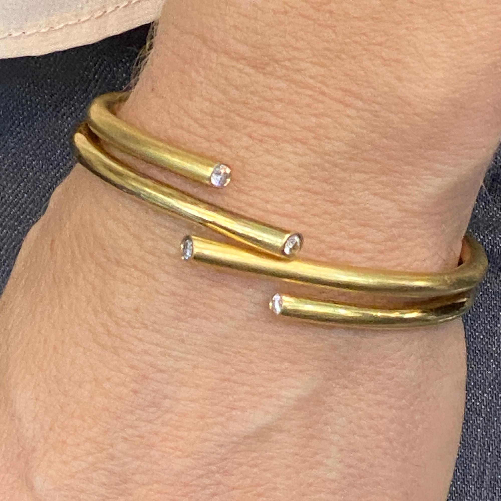 Fabulous hinged cuff bracelet by Greek designer Zolotas. The bypass modern cuff features four diamond endcaps (.40 CTW). The cuff is a mixture of high polish and satin finish gold. The bracelet measures .75 inches in width, and 2.25 inches in