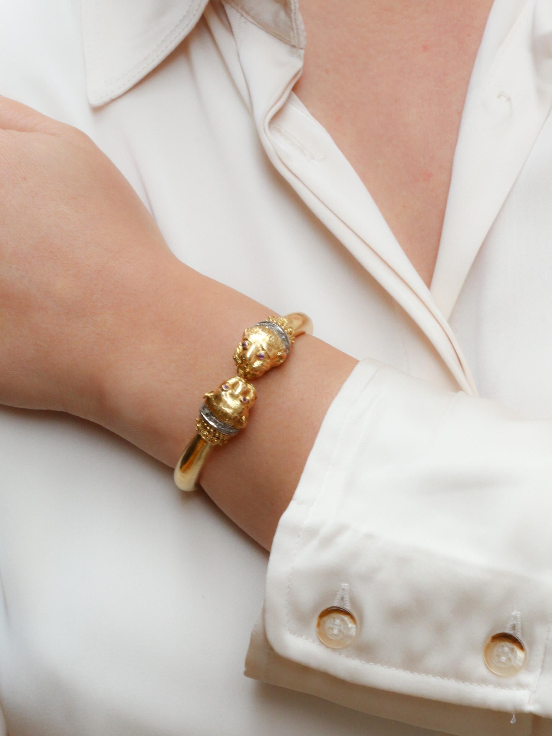 Bracelet rigide ouvrant en or 18k (750°/°°) à double tête de félin, les yeux sertis de rubis et les cous sertis de petits diamants taillés en rose. 
Ce bracelet iconique de Zolotas est une pièce très recherchée produite au début des années 1970.