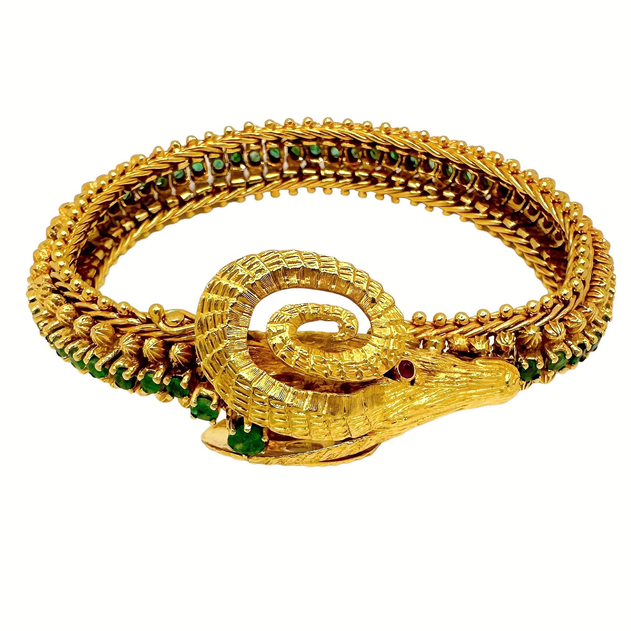 Highly regarded Greek jeweler Zolotas created this fanciful and unusual Rams head motif flexible bracelet. With a rich 24K gold wash, sultry ruby eyes, and a spine set entirely around with a single line of emeralds, this bracelet is a departure from