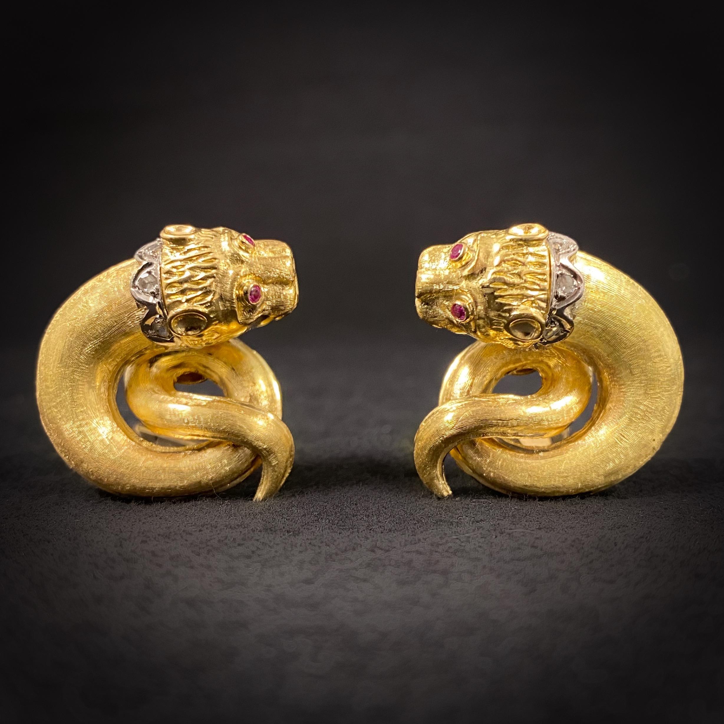 Zolotas Vintage Diamond and Ruby Mythical Mycenaen Lion Mask Earrings in 18K Yellow and White Gold, Greece, 1970s. Each carved lion’s head is accented by circular-shape ruby eyes and a rose-cut diamond collar set in white gold, issuing a textured