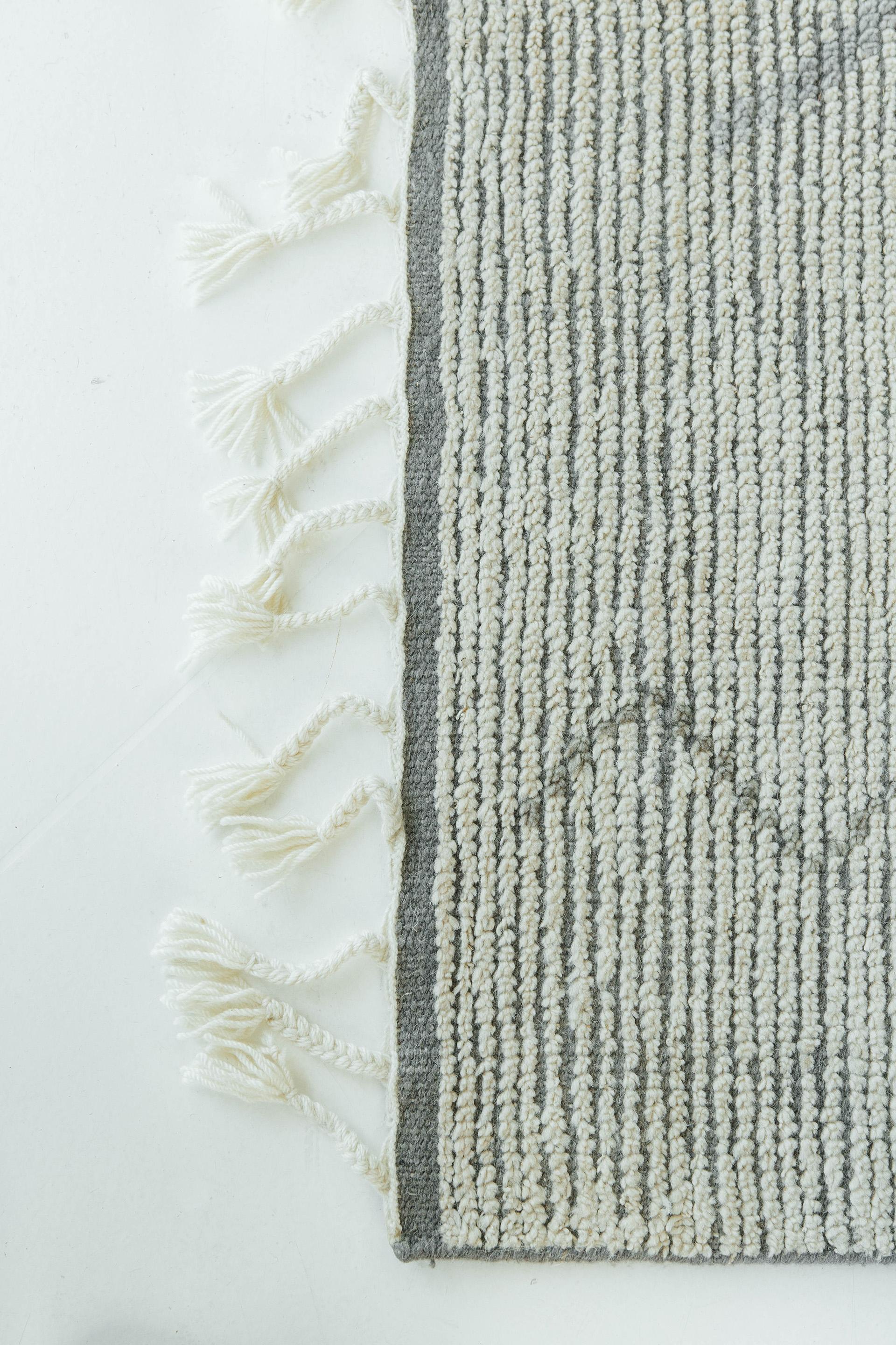 Designed in Los Angeles with inspiration from the Atlas Mountains of Morocco is this unique tribal rug. Weaved with handspun wool, this pile weave consists of a charming ribbed surface as well as intuitive diamond motifs that are latticed in pale