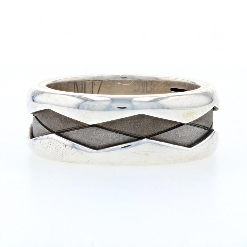 This striking band is sure to please any husband! The ring is comprised of three different metals. Containing sterling silver, stainless steel, and titanium the band starts with a polished strip that helps to form the chevron-like design for the
