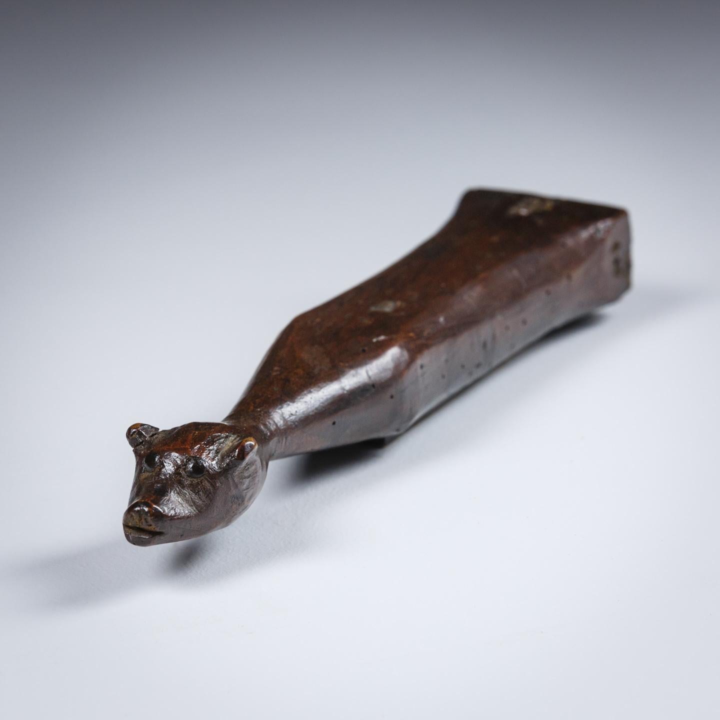 Unusual 19th century zoomorphic knife sharpening stone, in the form of a fox. Carved wood with stone set into the belly. Some evidence of historical worm. France, circa 1890.