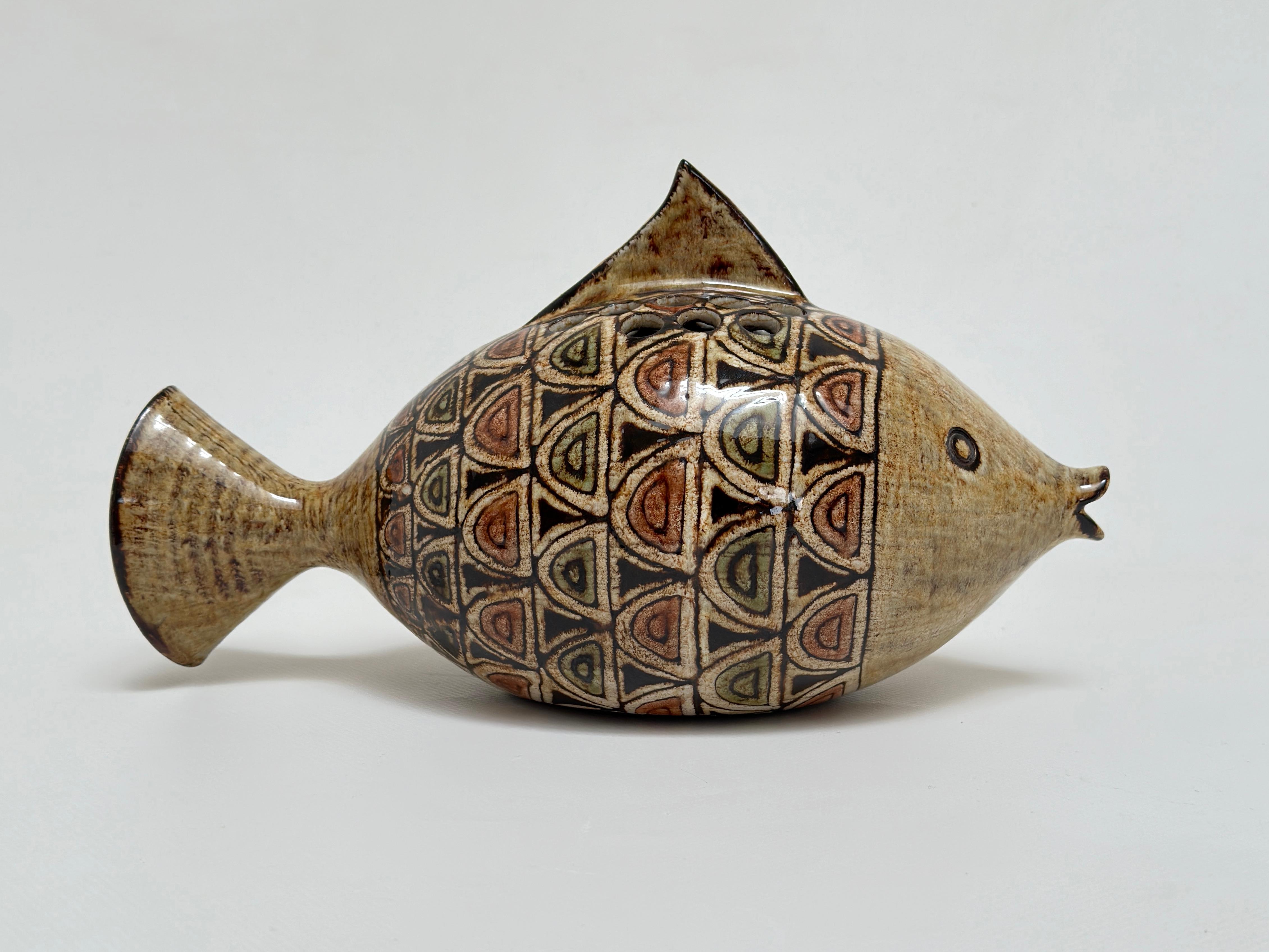 Gartenvase in Form eines Fisches in roter Erde aus Vallauris, Glasuren in gedeckten Tönen und Muster, die an orientalische Zierkeramik erinnern.

Jean-Claude Malarmey, Absolvent der Ecole des Beaux Arts in Reims, schloss sich 1954 seinem
