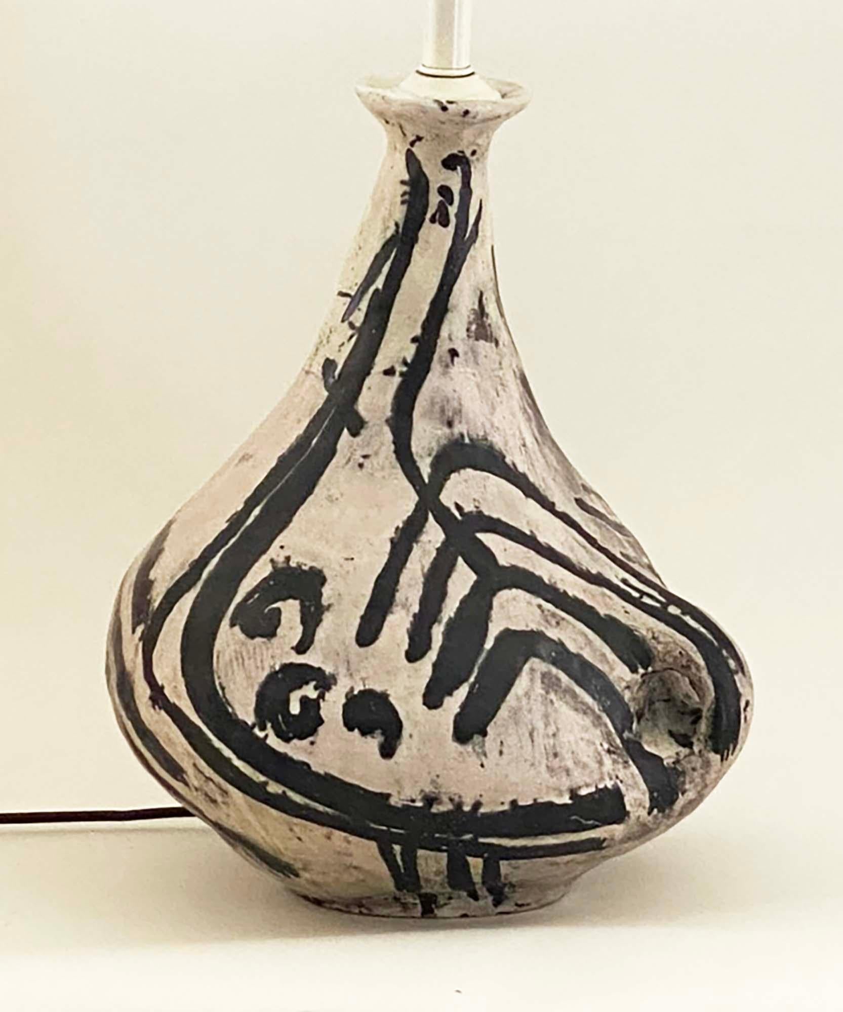 This is a unique and dramatic lamp hand-painted in black and white by Hungarian ceramicist Livia Gorka. There's a bit of a Picasso influence, but also reminiscent of Jacques Blin and other French ceramicists of the mid-century that celebrated