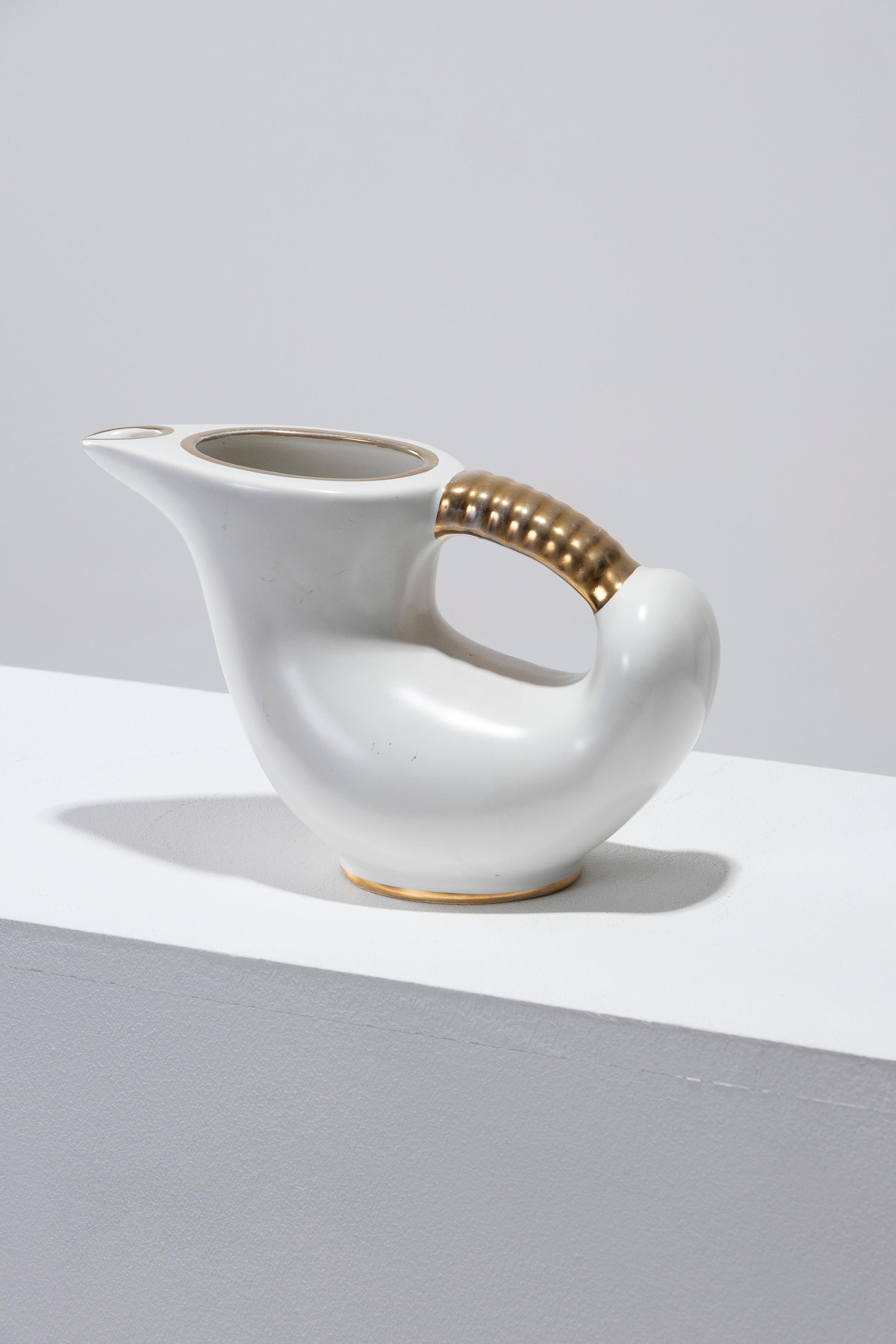 Delightful pitcher with a rounded body and a pointed spout, made in France in the 1950s. Finished with a white glaze, accented by gold lines, and a handle adorned with raised gold detailing. In excellent condition.
DV2046