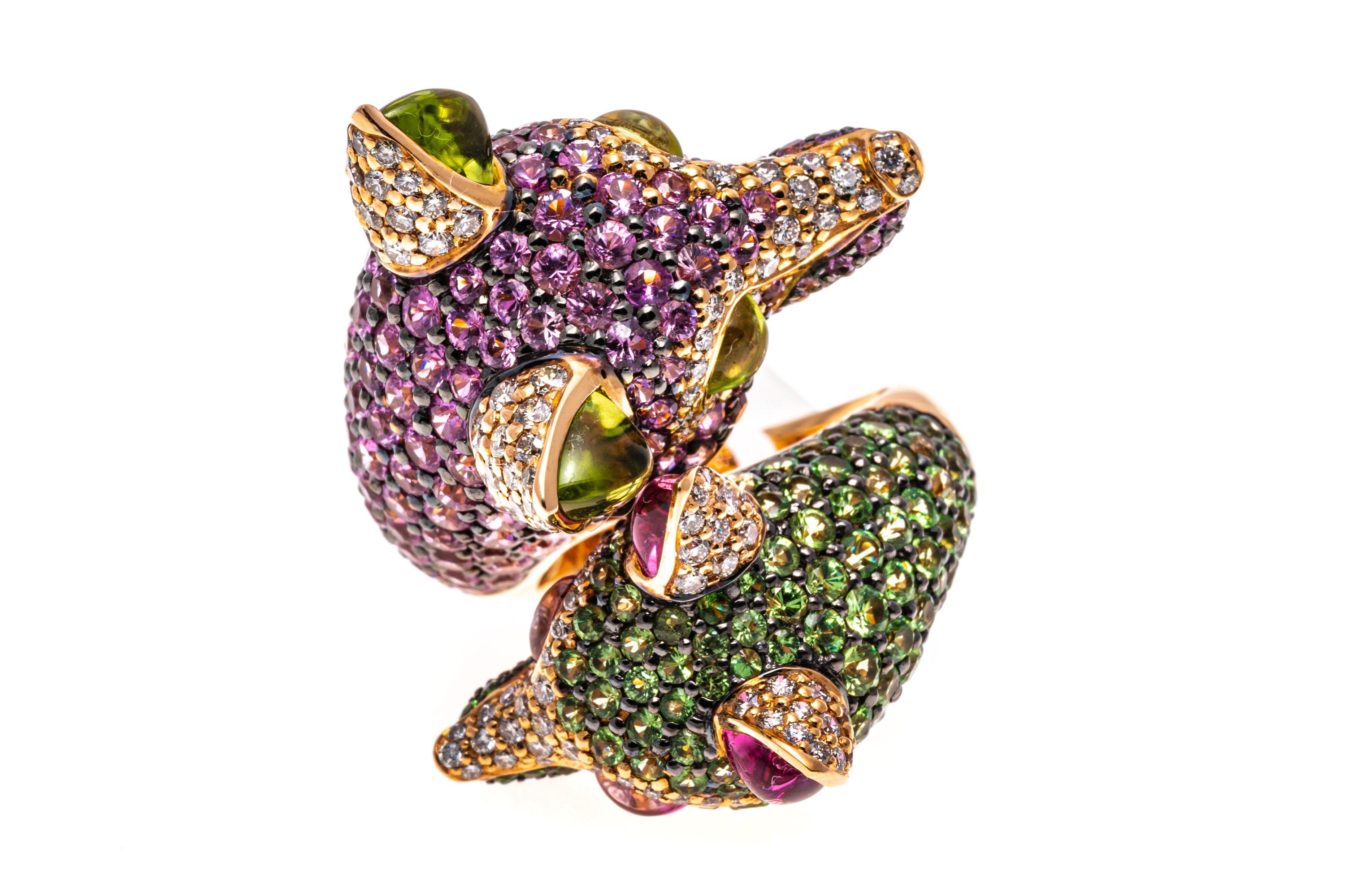 18k Rose Gold Double Fox Head Ring Set With Pink Sapphires, Diamonds, Tsavorite, Peridot.
This stunning ring is a bypass style featuring two opposing, complementary figural fox heads. The first and larger fox is pave set with round faceted, medium
