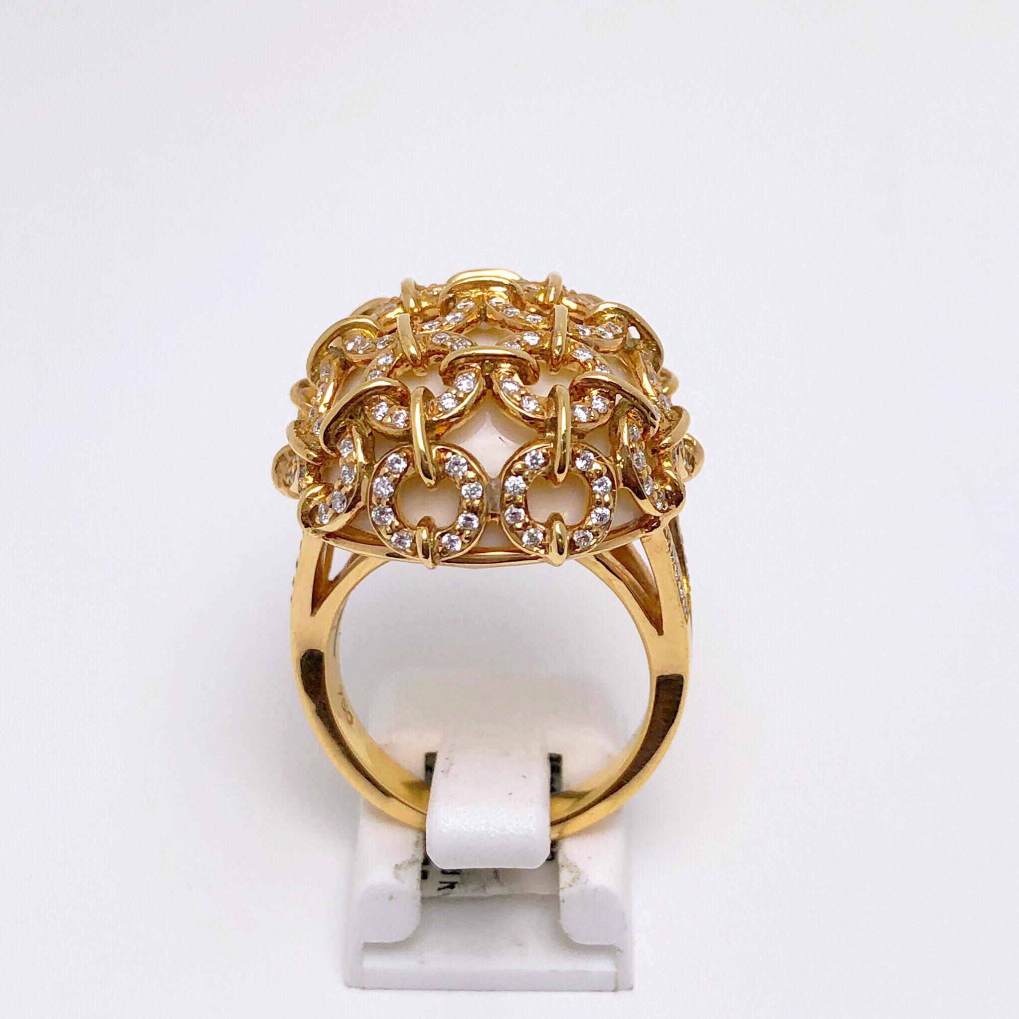 A lovely cocktail ring featuring a beautiful oval shaped cabochon opal. The opal is milky white and is caged in round links that have been set with brilliant diamonds. Two rows of diamonds come midway down the shank forming a V. The entire ring is
