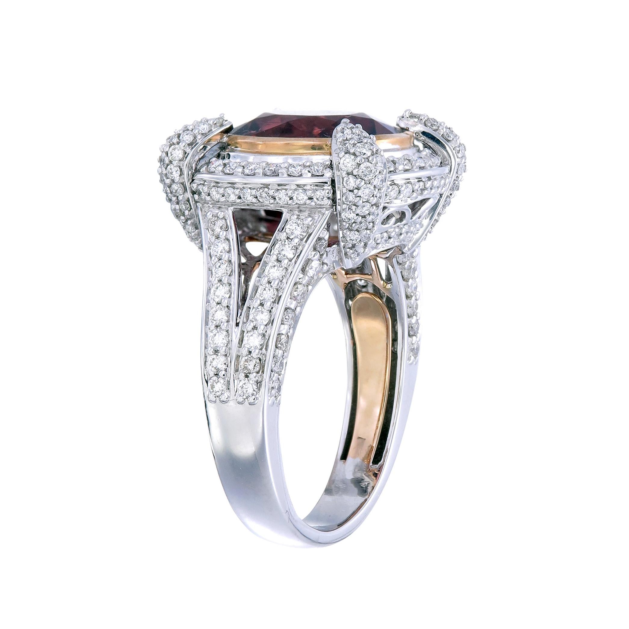 A round 4.81-carat fancy red tourmaline in a deep lush hue centers this 18k gold and palladium ring paved with 1.24-carats of diamonds. This round stone surrounded by a halo setting would make a wonderful engagement ring for a bride who has the