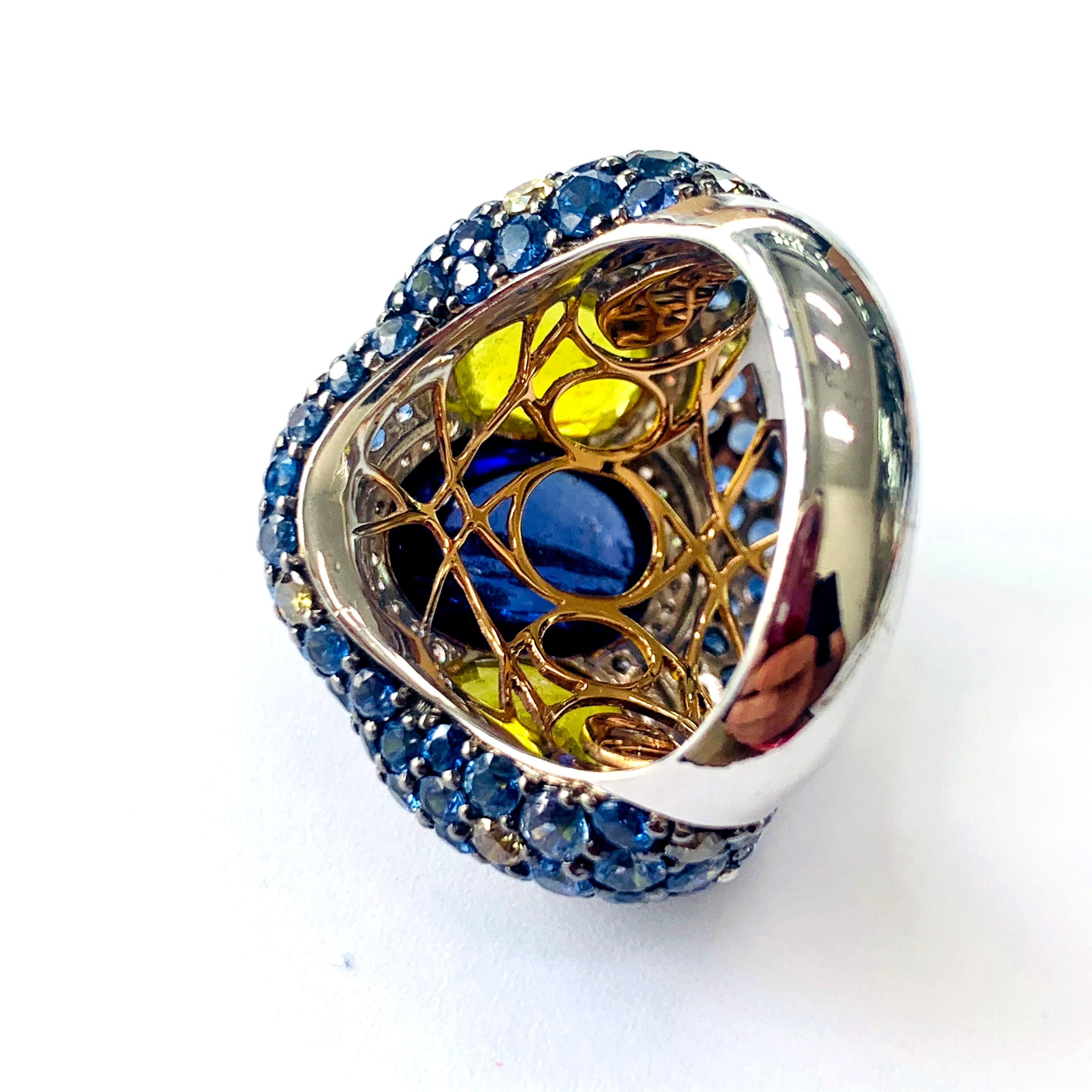 This is a ring that makes a bold statement for any high profile event. A 7.73-carat oval-shaped tanzanite with a textured finished is flanked by two oval-shaped yellow tourmalines with a total weight of 4.06 carats. The three gems are surrounded by