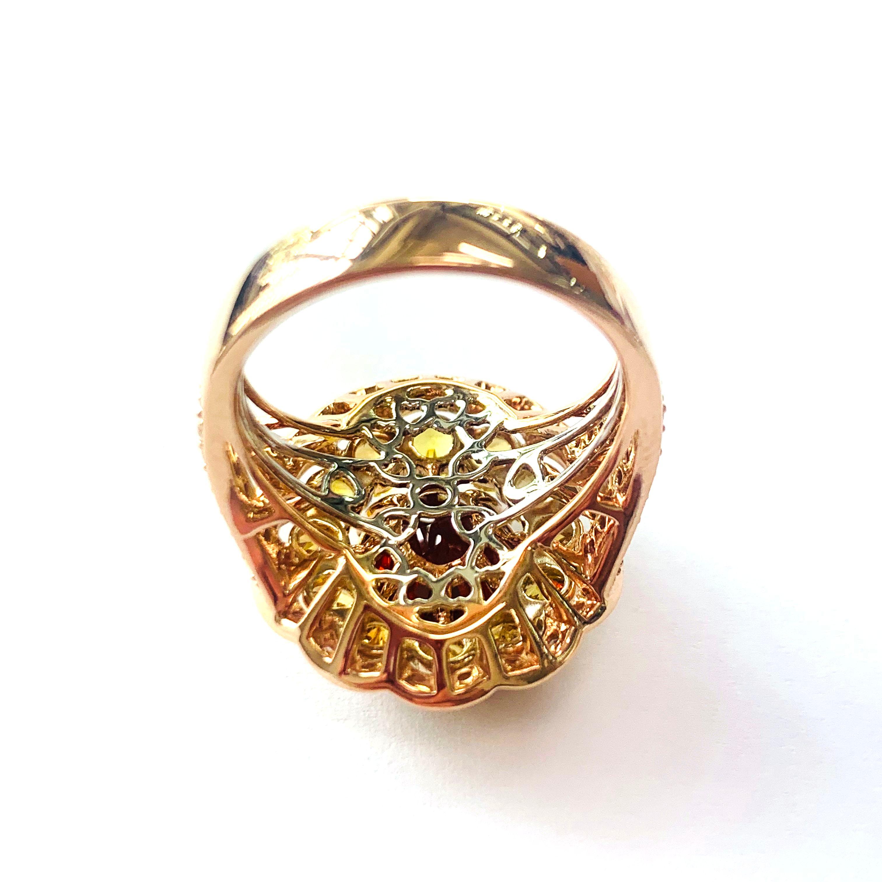 Un granato spessartite da 7,96 carati è il fulcro di questo anello tricolore a 18 carati che rappresenta un'audace dichiarazione da sera. Quasi  3 carati di zaffiri gialli rotondi e una spruzzata di diamanti bianchi da 0,46 carati completano questo