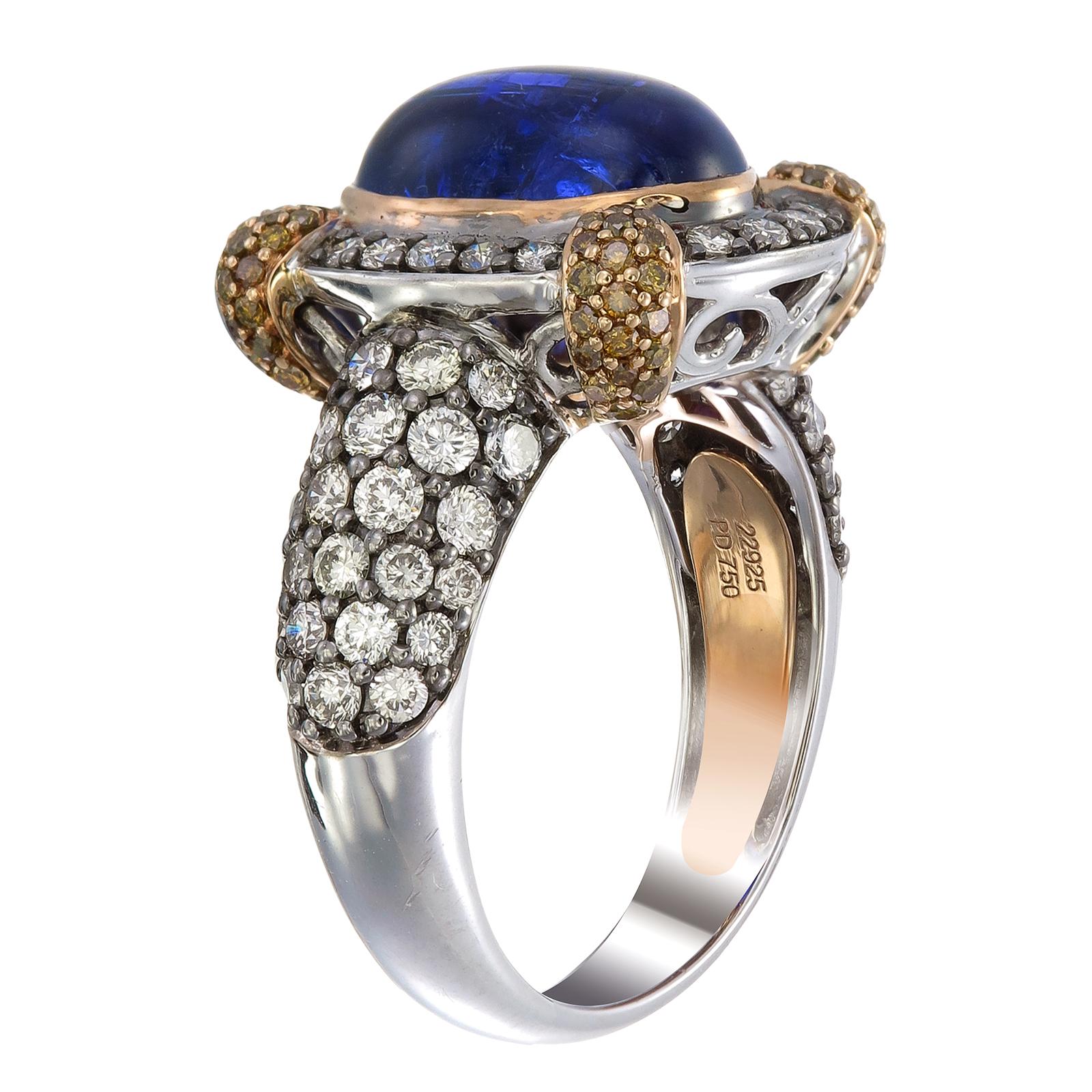 Sur un trône d'or et de diamants trône une tanzanite bleue de 6,81 carats, maintenue par des griffes pavées de diamants de couleur fantaisie de 0,47 carat. L'épaule et la tige de la bague en palladium et or 18 carats sont serties de 1,75 carat de