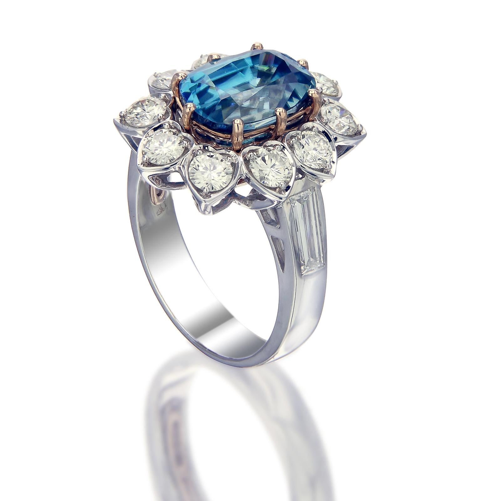 A 5.35-carat translucent blue zircon is the centerpiece of this 18k gold and palladium ring. The gem is surrounded by 1.74-carat round white diamonds in pear-shaped settings. The shank of the ring is set with emerald baguette diamonds on either