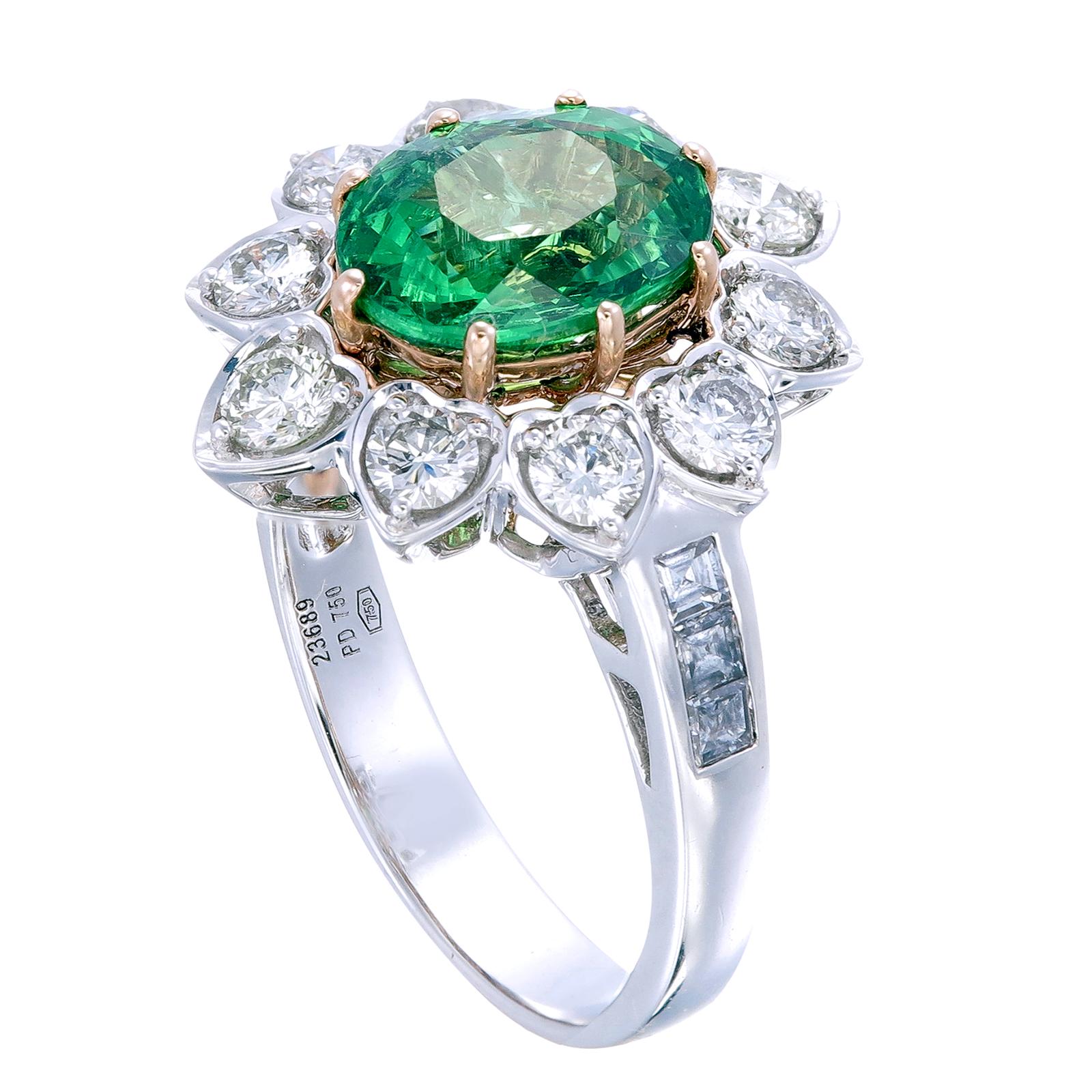 A 2.89-carat oval-shaped translucent tsavorite is the focal point of this elegant ring. It’s surrounded by 1.13-carat round diamonds in pear-shaped settings with each point further adorned with another small round diamond. The shank of the ring is