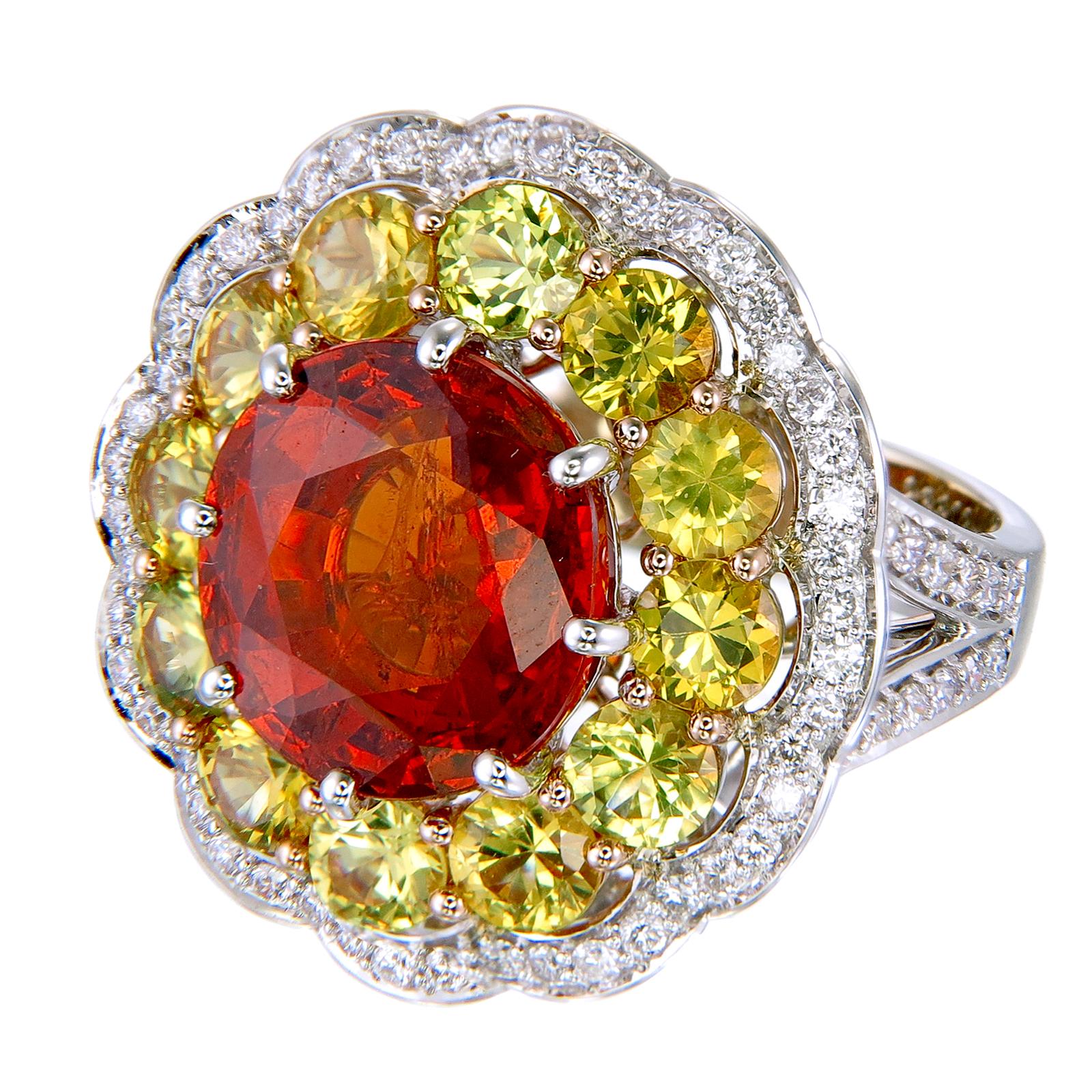 Bright colors and multiple spinning motifs create an energizing and fun jewel that can make any day brighter. An 8.38-carat round Spessartite Garnet is surrounded by a row of round 3.40-carat Yellow Sapphires which is surrounded by round 0.63-carat