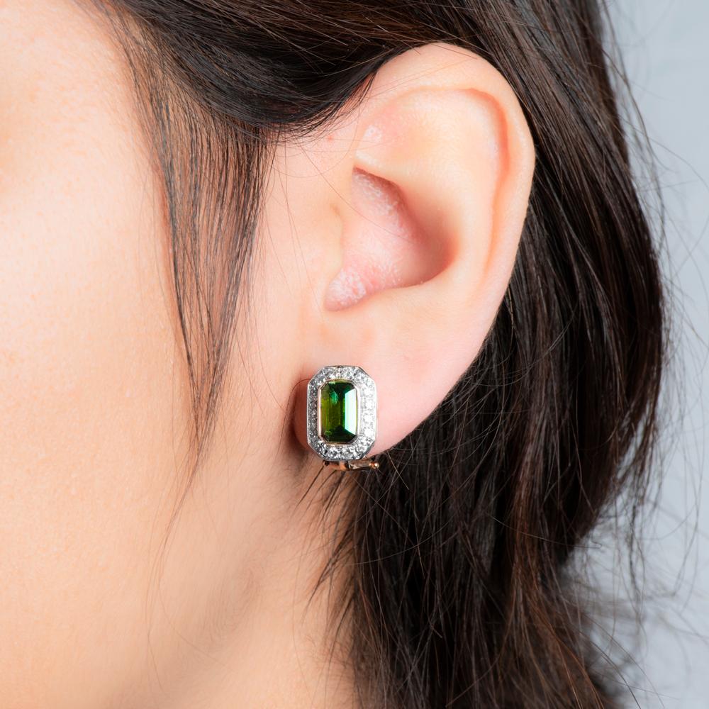 Ces exquis clous d'oreilles en tourmaline et diamant blanc sont d'une opulence absolue dans leur conception et leur fabrication. 
La tourmaline octogonale de couleur olive est entourée d'une pléthore de délicats diamants blancs et nichée dans une