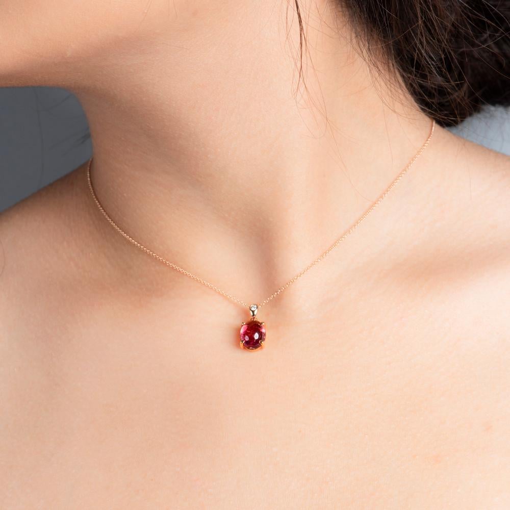 Minimalistic doesn't mean plain vanilla.  A clean design welcomes a deep, passionate color touch. 

Radiating from your neckline will be a decent 3.25 carats of deep raspberry pink tourmaline. Set in an oval, silky smooth cabochon bezel, it begs to