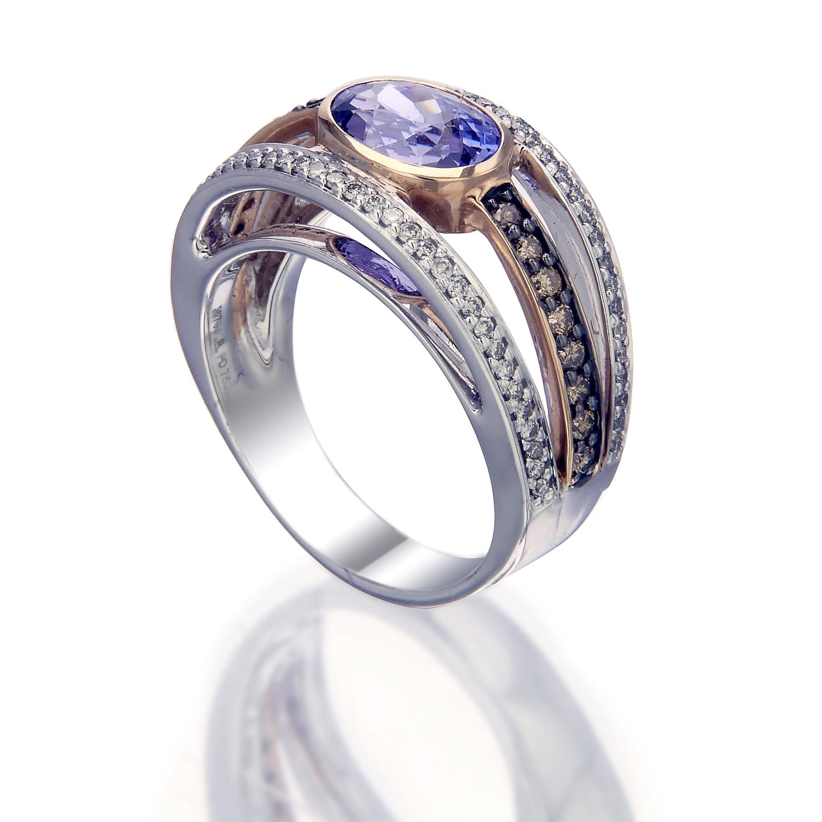 Ein beeindruckender Ring aus Palladium und 18 Karat Roségold mit dem warmen Glanz eines ovalen Tansaniten von 2,65 Karat, der von drei Reihen weißer Diamanten von 0,36 Karat und gelber Diamanten von 0,35 Karat gesäumt wird. Es ist ein Schmuckstück