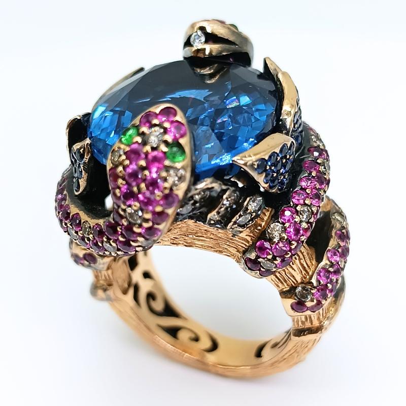 Zorab Ring in Yellow Gold 18K with central cobalt blue Topaz with two snakes and decorative leaves.
4 green Sapphires
144 pink Sapphires
58 blue Sapphires
51 Diamonds