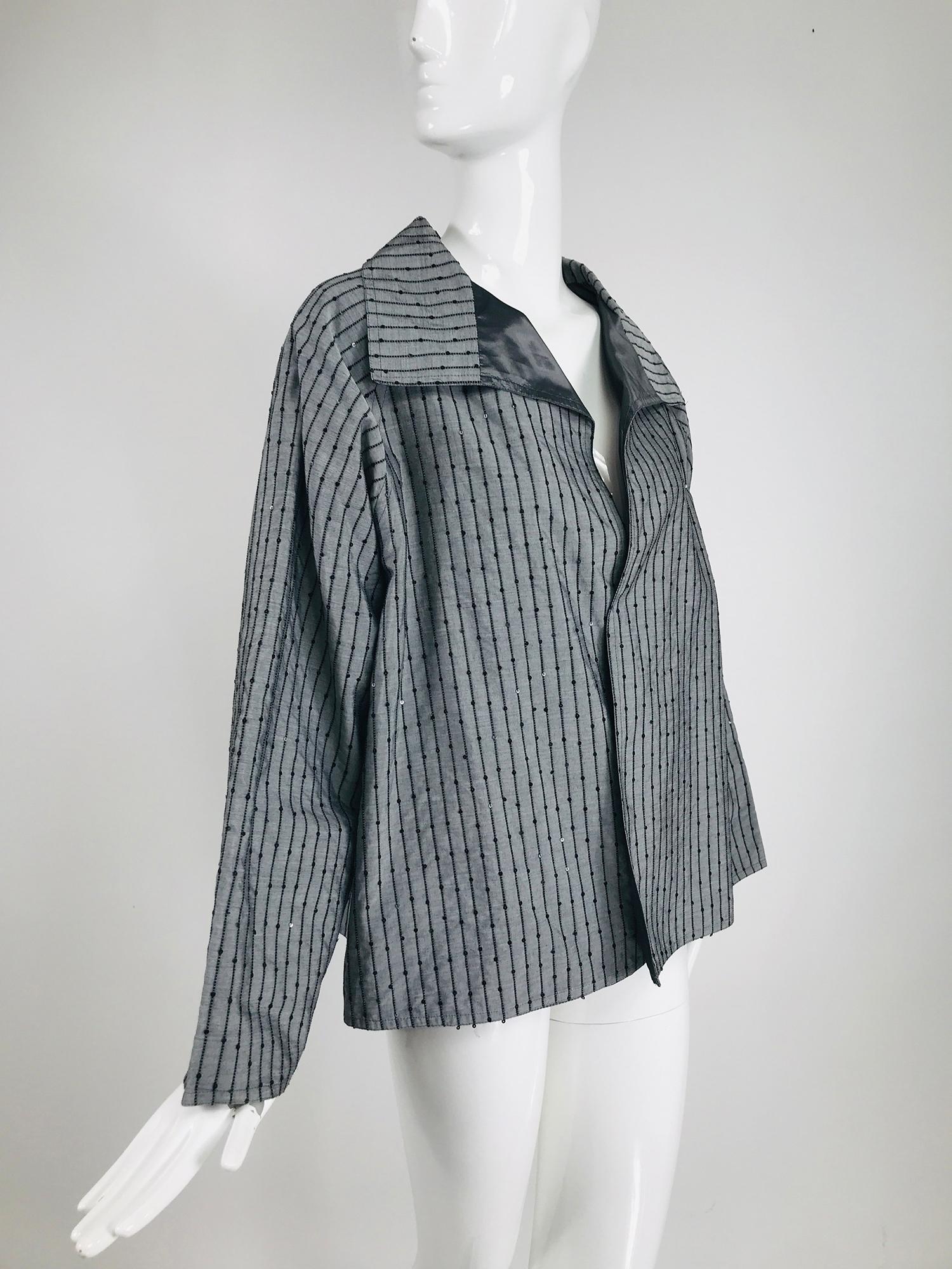 Zoran charcoal grey raised cord stripe with sequins swing jacket. Interesting fabric in charcoal silk with vertical appliqued raised cord which is interspersed with tiny sequins. Wing collar jacket has full raglan sleeves, the jacket is open at the