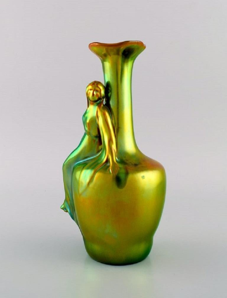 Zsolnay Art Nouveau vase in glazed ceramics modelled with a sitting woman. 
Beautiful eosin glaze. 1920/30s.
Measures: 24 x 13 cm.
In excellent condition.
Stamped.