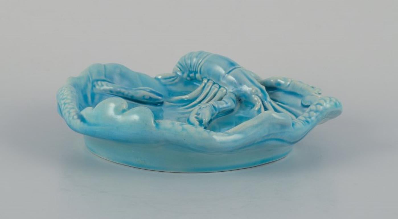 Zsolnay, Hungary, Art Nouveau wall plate in ceramic with lobster and snake.
Turquoise glazed.
Approx. 1910.
Unmarked.
In excellent condition.
Dimensions: D 18.0 cm x H 4.5 cm.

