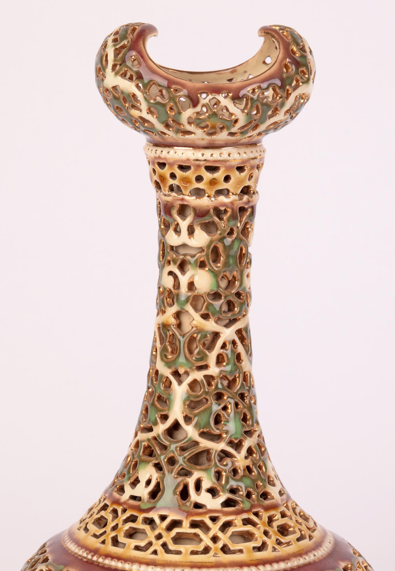 A stylish and elegant Hungarian ceramic vase of Islamic style and shape with pierced designs by renowned maker Zsolnay Pecs and dating from around 1890. This impressive vase stands raised on a narrow round pedestal base with a round onion shape body