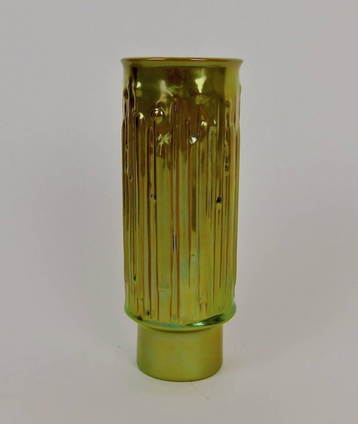 A striking cylindrical art pottery vase from the Zsolnay Pecs ceramics factory of Hungary, The Modernist design is enveloped in the firm's signature metallic golden-green 'eosin' glaze. Very good, undamaged condition measuring 8.5 in

During the