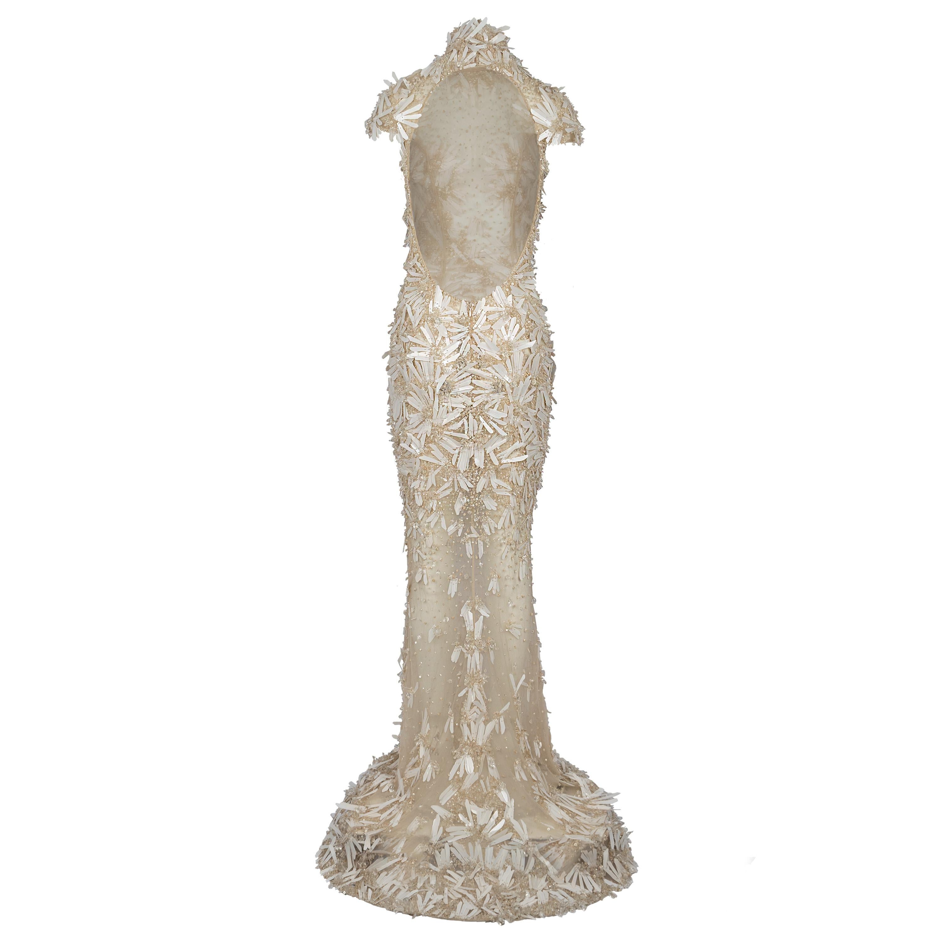Enchant every crowd with a mythical entrance in the white Zuhair Murad crystal open-back dress with paillettes. The contrast of the modern sheer mesh areas with the reserved closed neck with cup sleeves is one of the captivating elements that this